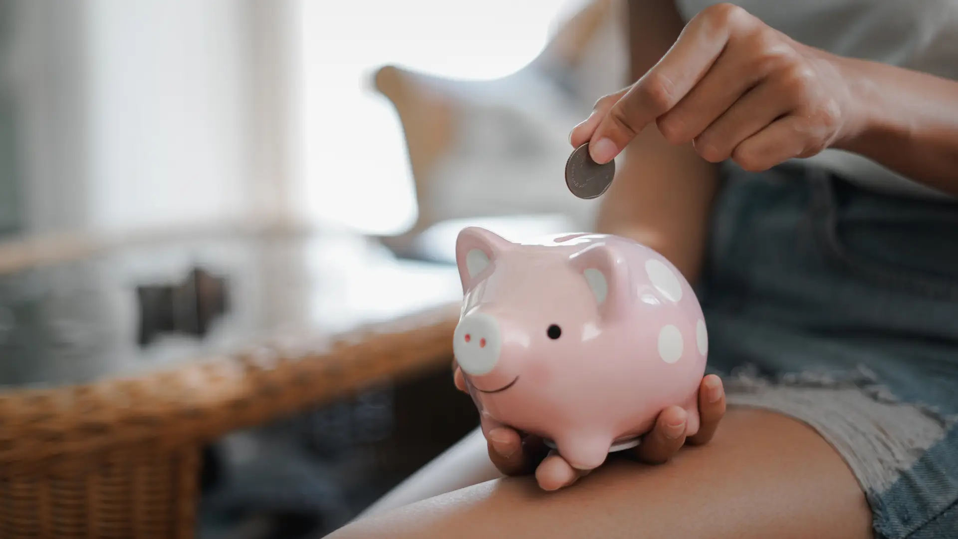 Metiendo monedas en una hucha de cerdo para representar el seguro ahorro de HNA Metiendo monedas en una hucha de cerdo para representar el seguro ahorro de HNA