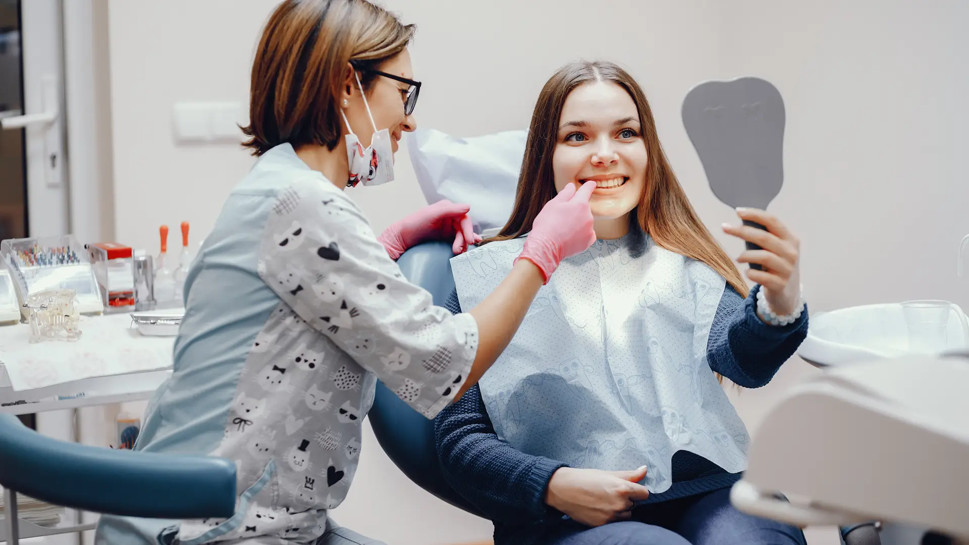 Mujer con seguro dental imq revisandose los dientes frente a espejo Mujer con seguro dental imq revisandose los dientes frente a espejo