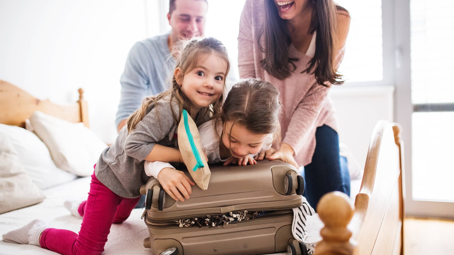 Familia preparando la maleta para irse de vacaciones con seguro de viaje imq Familia preparando la maleta para irse de vacaciones con seguro de viaje imq