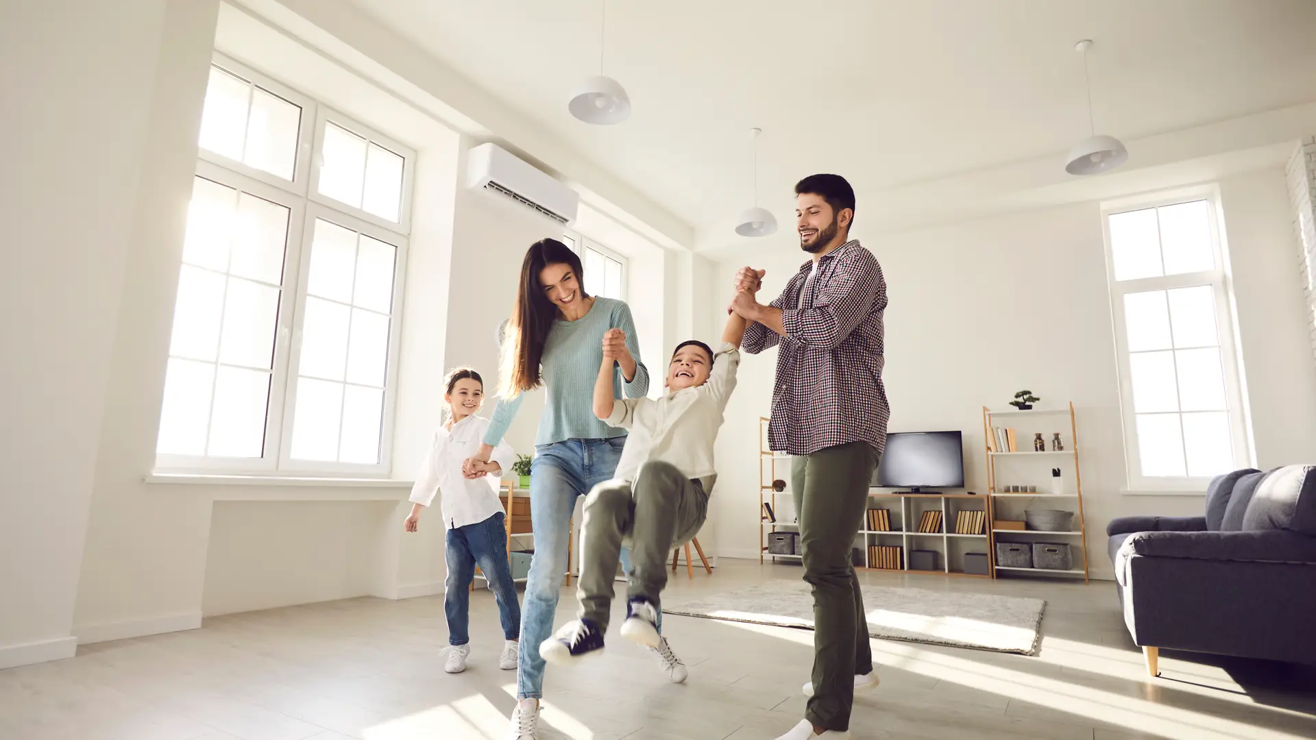 Una familia jugando en el salon de casa tranquilos porque tienen un seguro de hogar esencial de la empresa Linea Directa