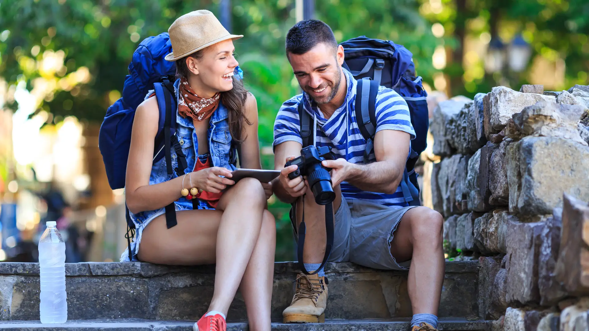 Pareja sonríe mientras revisa fotos de su viaje con la tranquilidad de contar un seguro de viaje de línea directa Pareja sonríe mientras revisa fotos de su viaje con la tranquilidad de contar un seguro de viaje de línea directa