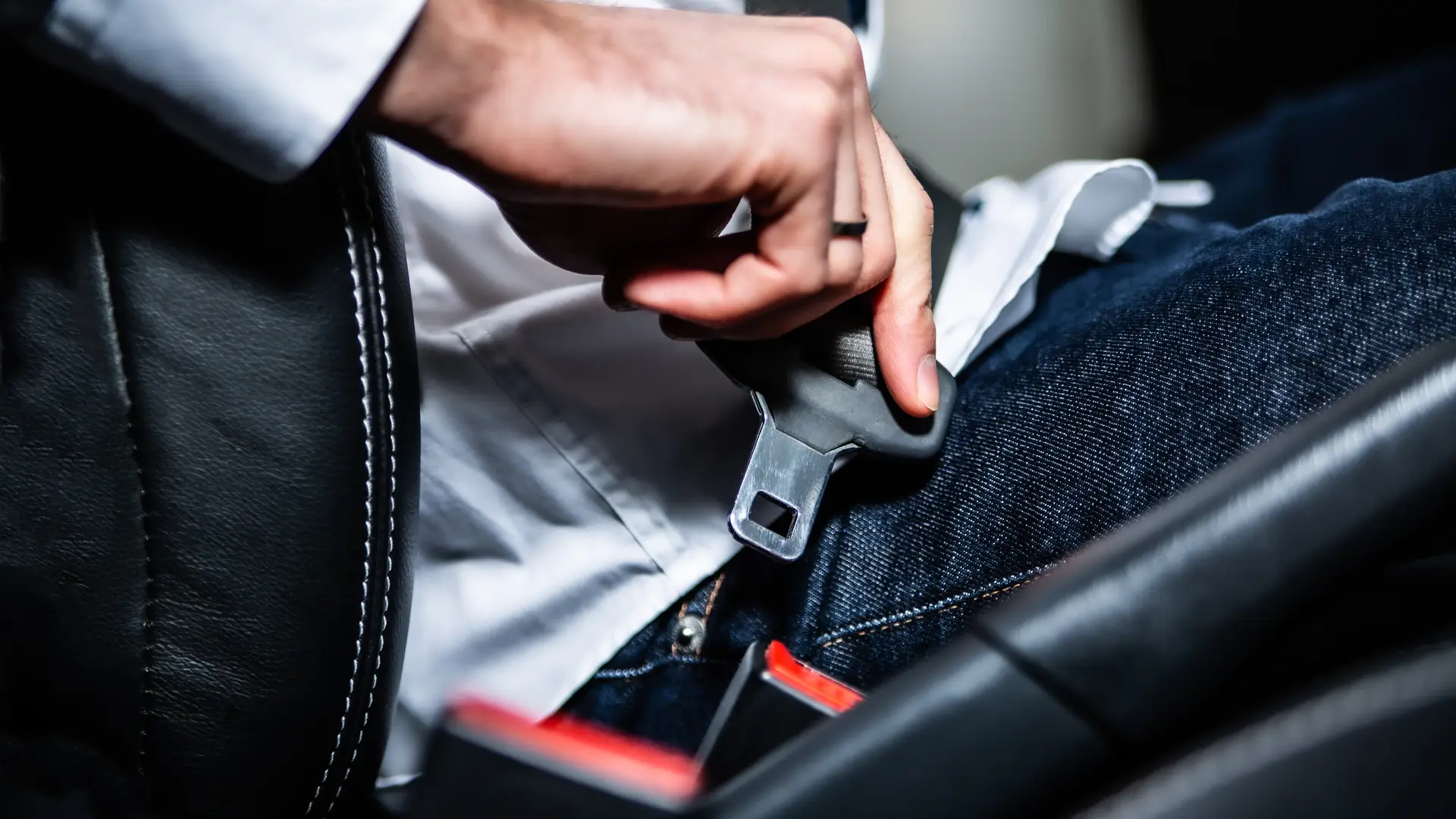mano de un chico atandose el cinturon de su coche asegurado con linea directa suma mano de un chico atandose el cinturon de su coche asegurado con linea directa suma