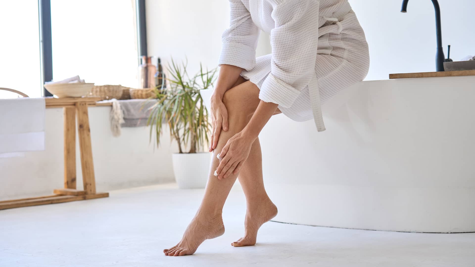 Mujer dándose el masaje que le recomendó su medico cirujano vascular para evitar dolores en sus piernas con varices 