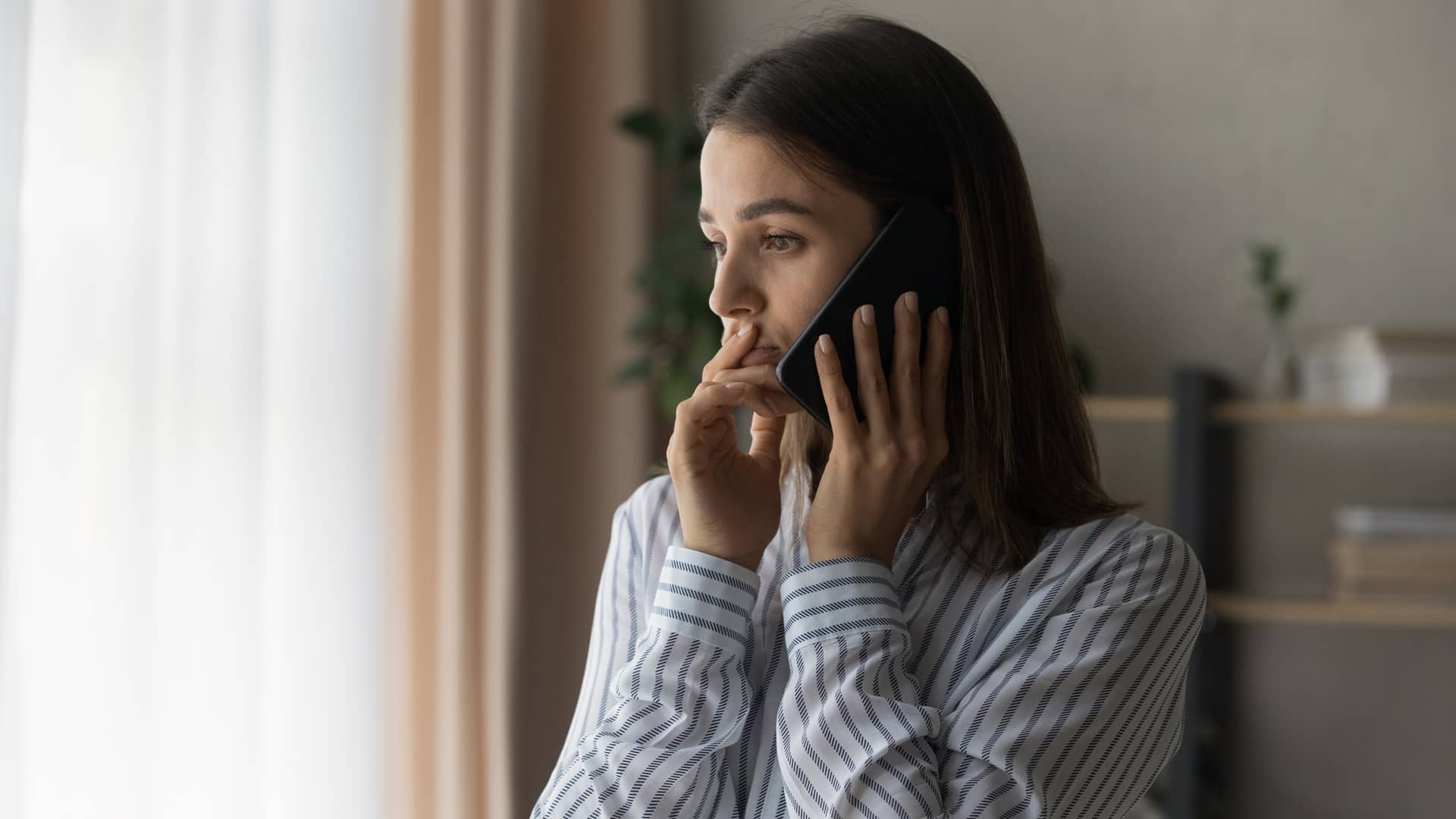 Mujer con cara de tristeza hablando con su seguro mapfre para dar un parte