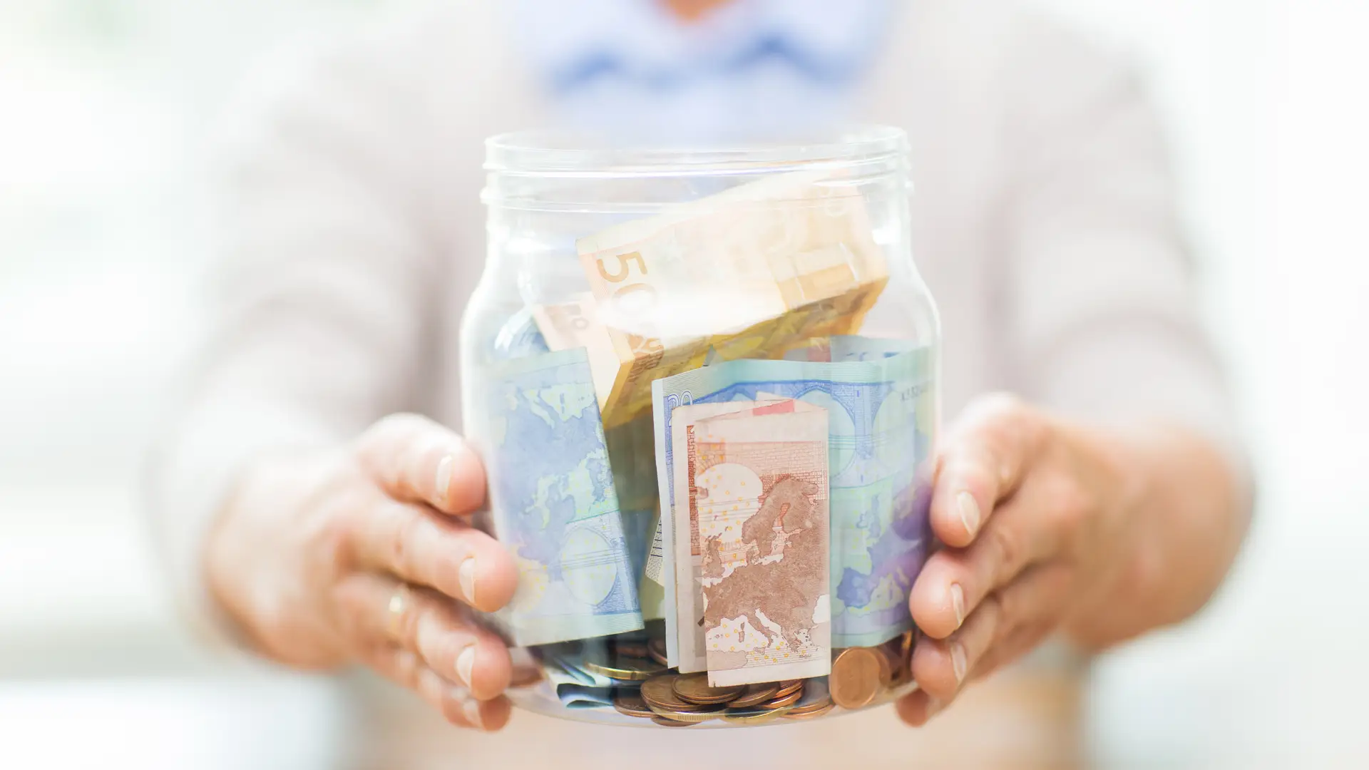 Bote lleno de monedas y billetes representa el ahorro al contratar aseguradora mapfre Bote lleno de monedas y billetes representa el ahorro al contratar aseguradora mapfre