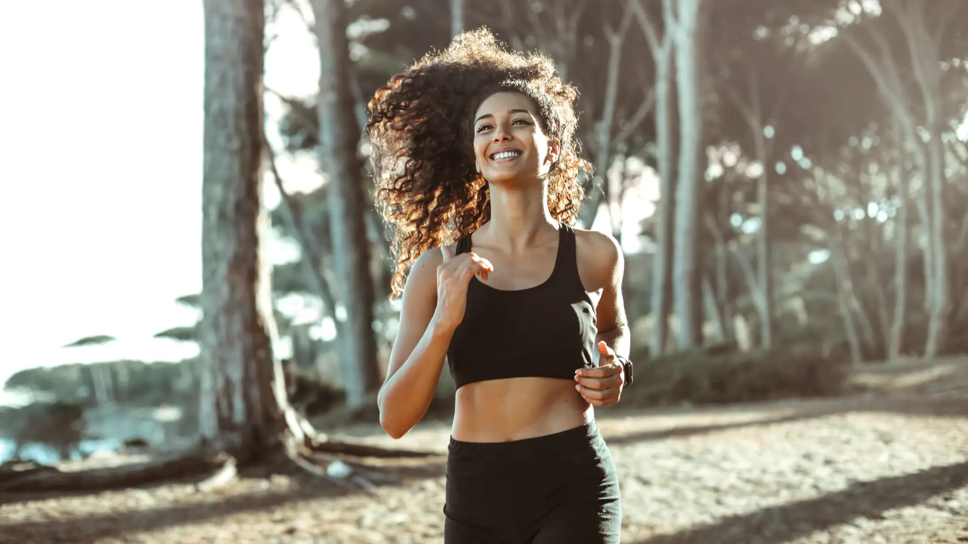 Mujer practicando deporte sonriente por pinar con seguro de vida contratado con mapfre Mujer practicando deporte sonriente por pinar con seguro de vida contratado con mapfre