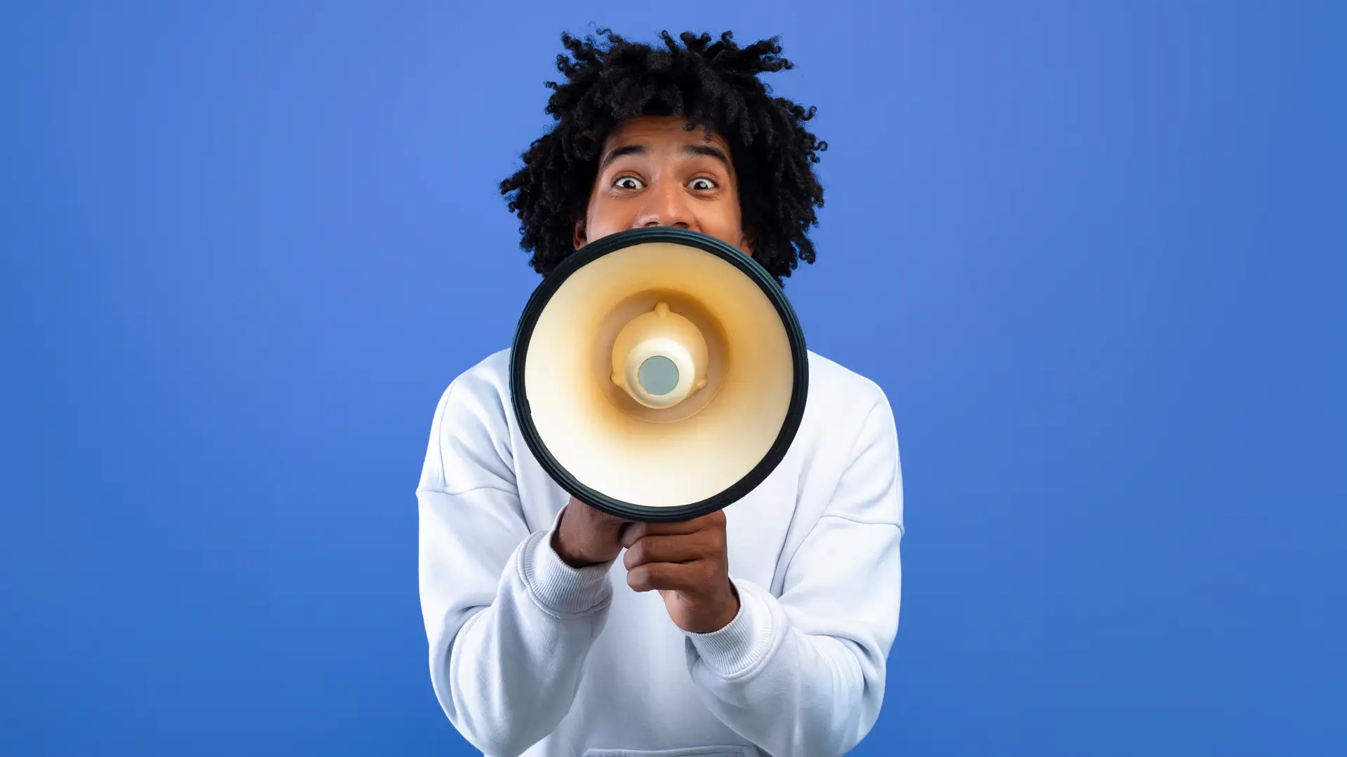 Chico gritando con un megáfono que representa las opiniones de MMT Seguros