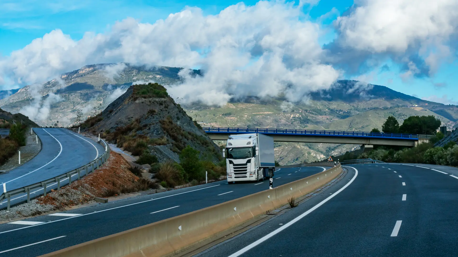 Camión con seguro en mutua madrileña circulando por autovía de montaña Camión con seguro en mutua madrileña circulando por autovía de montaña