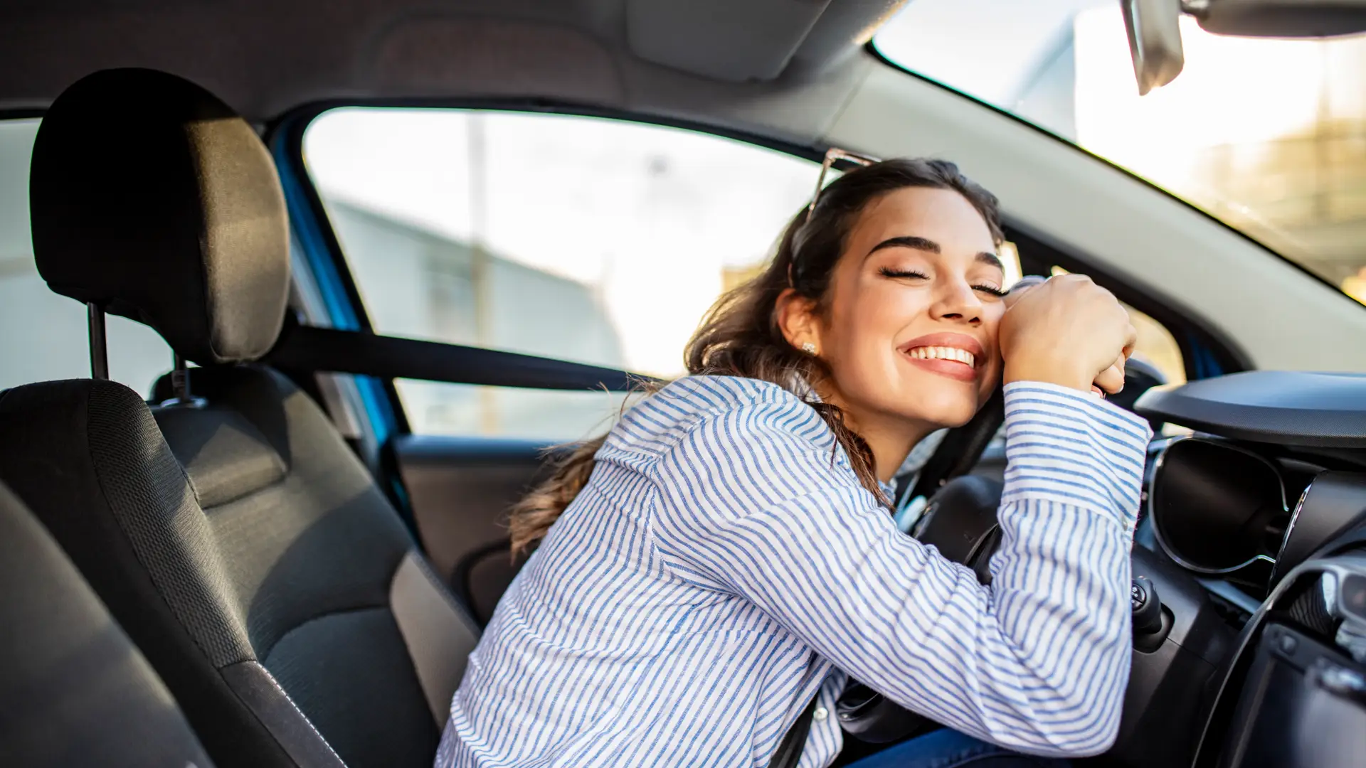 Mujer alegre con su nuevo coche con seguro a todo riesgo en la mutua madrileña