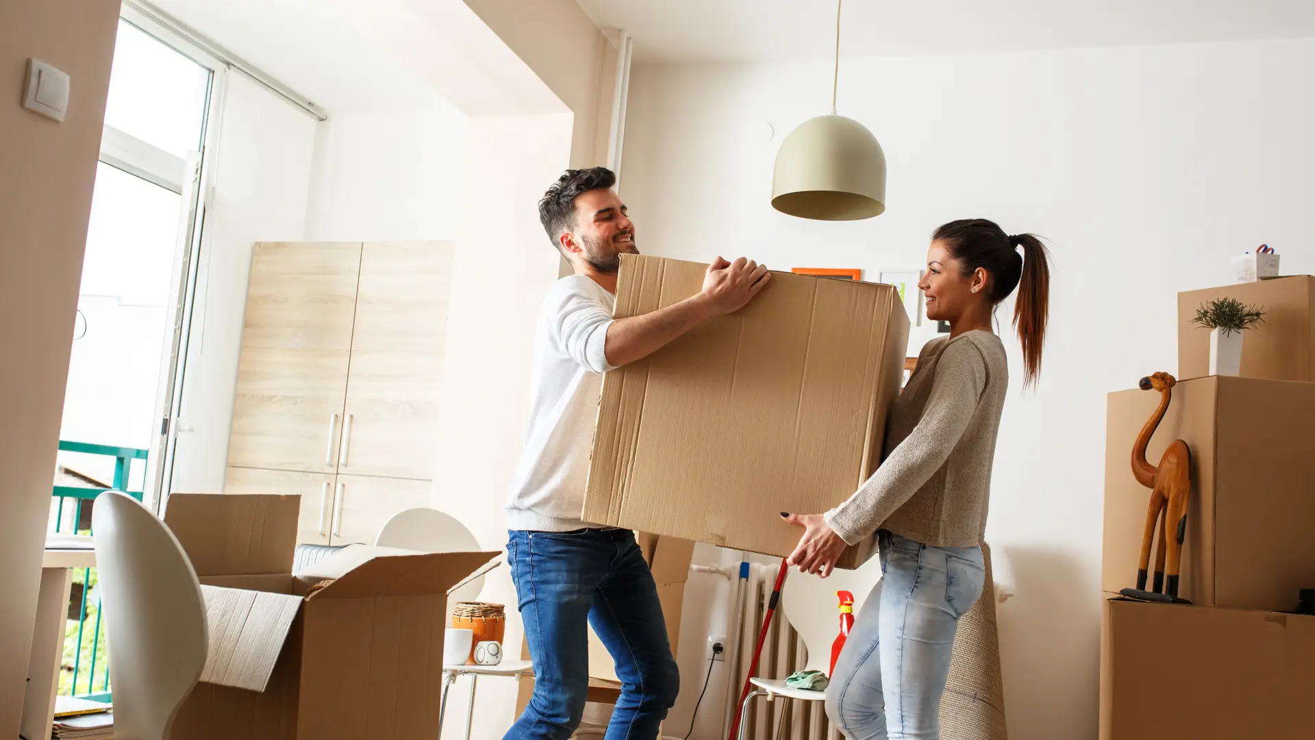 Una pareja joven ordenando las cajas de la mudanza a un piso donde el casero tiene contratado el seguro de hogar y de arrendamiento con la Mutua Madrileña Una pareja joven ordenando las cajas de la mudanza a un piso donde el casero tiene contratado el seguro de hogar y de arrendamiento con la Mutua Madrileña