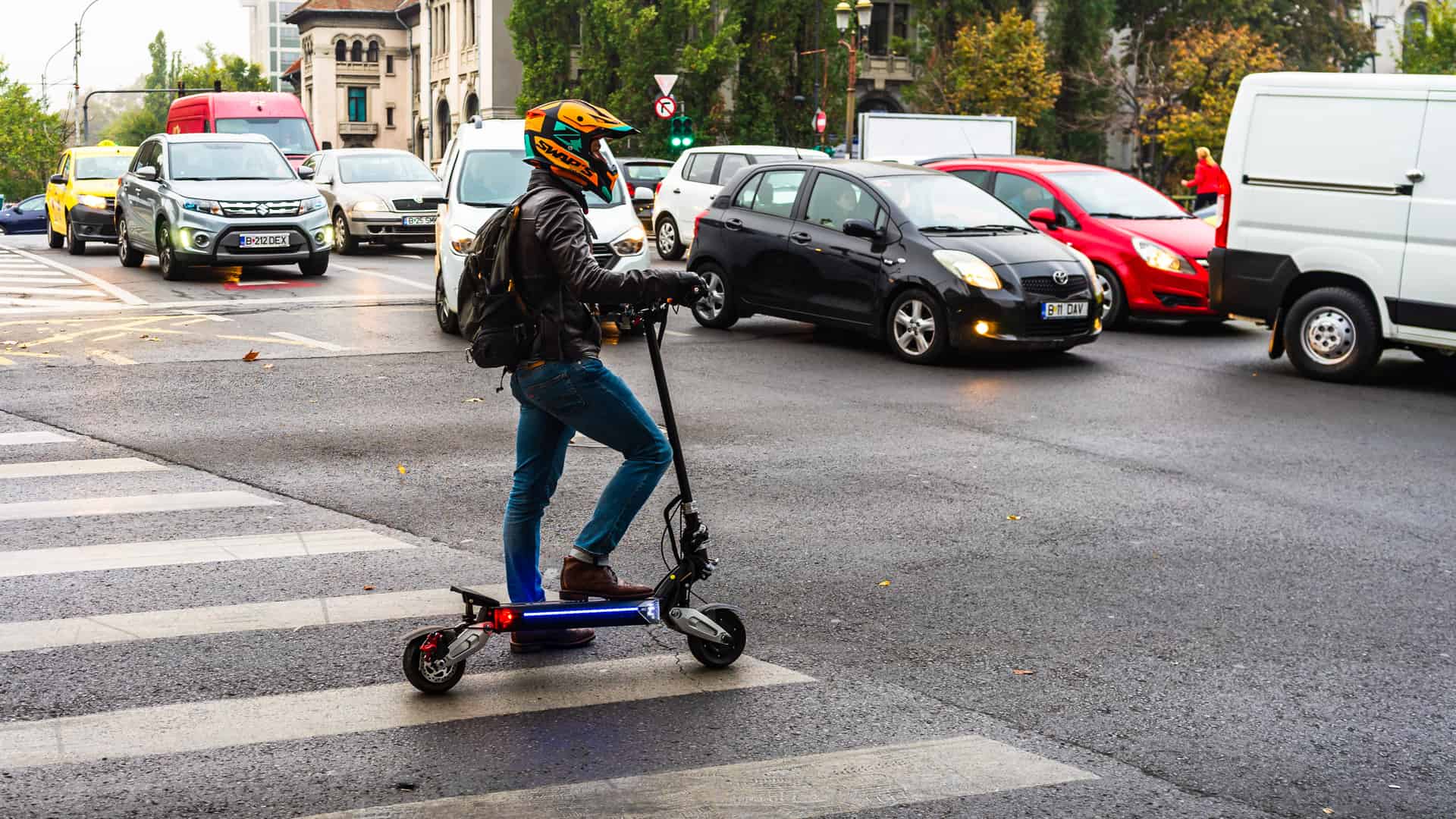 Un joven en plena ciudad sobre su patinete eléctrico sin seguro para patinetes de la Mutua Madrileña Un joven en plena ciudad sobre su patinete eléctrico sin seguro para patinetes de la Mutua Madrileña