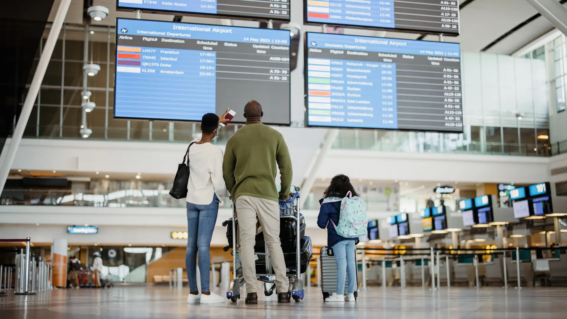 Una familia de espaldas en el aeropuerto que se va de vacaciones con su seguro de viajes de la Mutua Madrileña Una familia de espaldas en el aeropuerto que se va de vacaciones con su seguro de viajes de la Mutua Madrileña