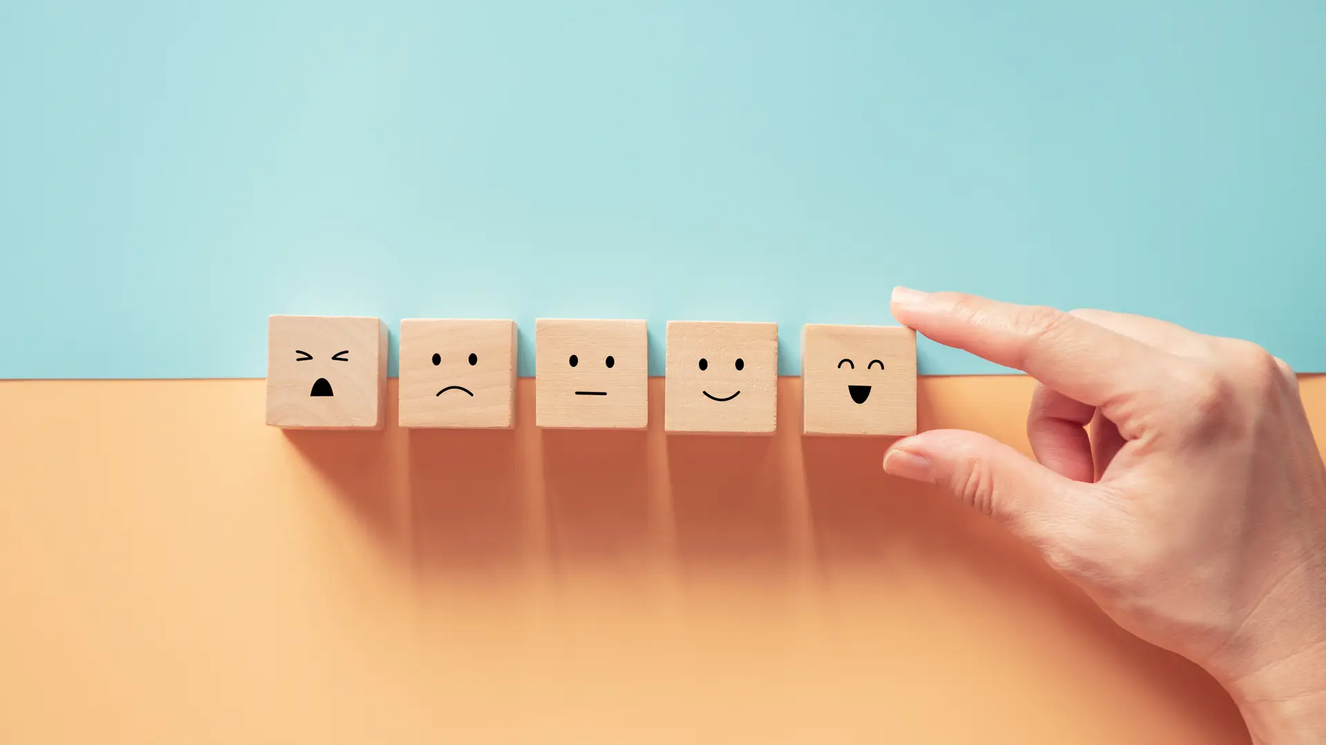 Persona escogiendo dado con cara sonriente para dar opinión de aseguradora ocaso