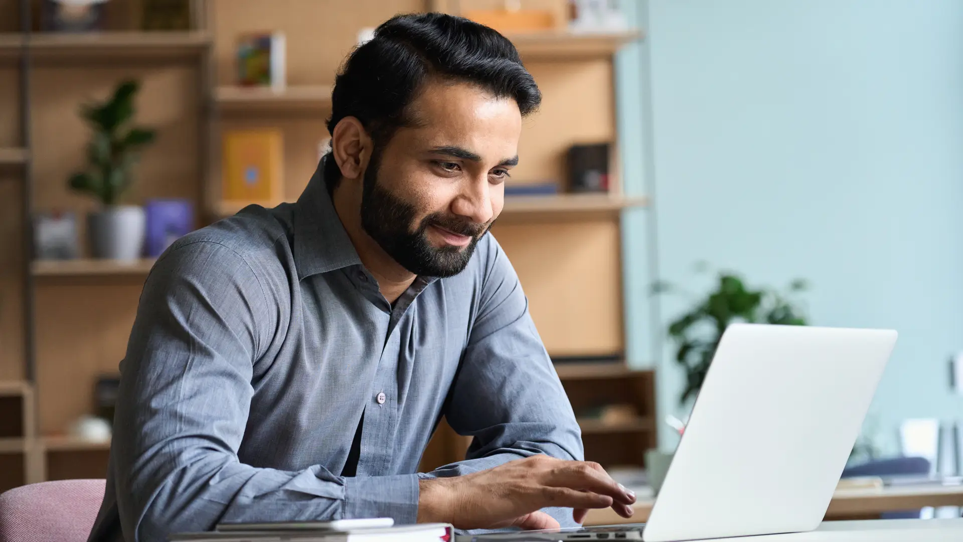 un hombre contento mirando la pantalla de su ordenador despues de ver el ahorro de su seguro con ocaso un hombre contento mirando la pantalla de su ordenador despues de ver el ahorro de su seguro con ocaso