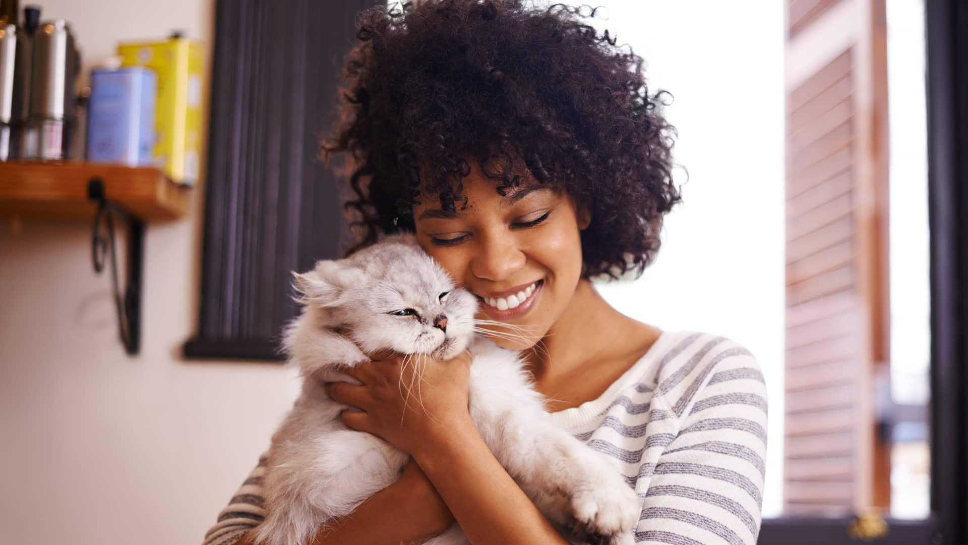 Mujer abrazando a su gato con seguro de mascotas con ocaso seguro Mujer abrazando a su gato con seguro de mascotas con ocaso seguro