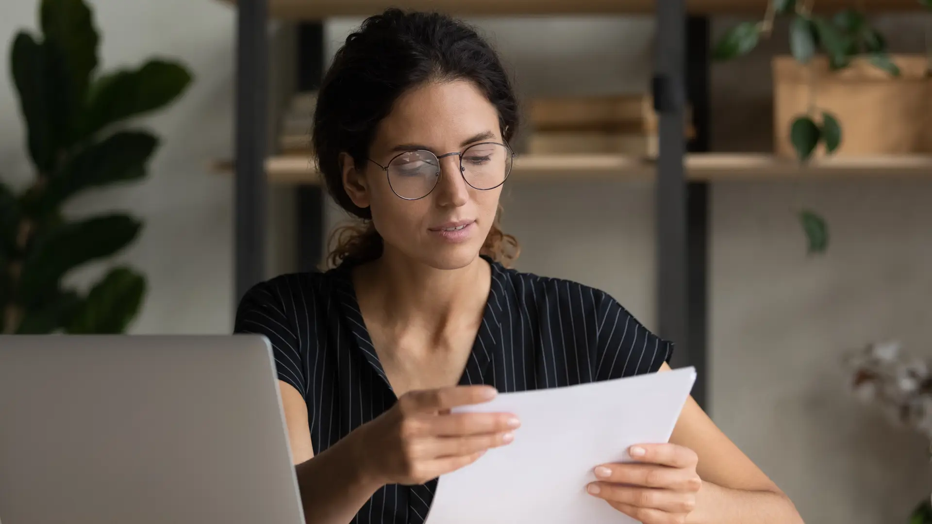 Una chica seria preparando la documentacion para dar de baja su seguro de vida de la empresa Plus Ultra