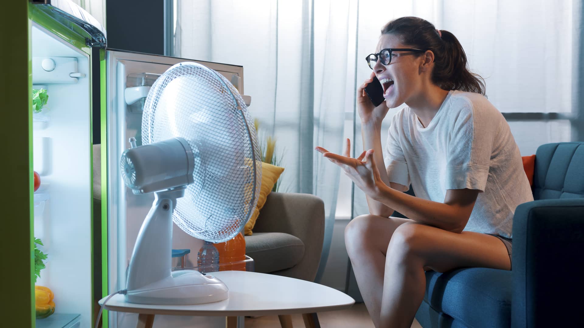 Mujer enfadada hablando por teléfono con su seguro plus ultra para dar parte de su aparato acondicionado Mujer enfadada hablando por teléfono con su seguro plus ultra para dar parte de su aparato acondicionado