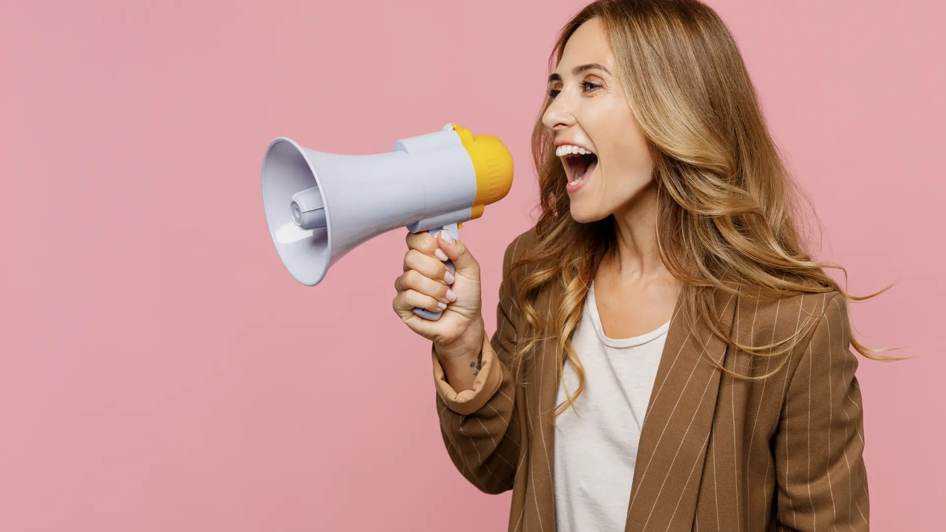 Una chica joven sobre un fondo rosa gritando con un megáfono que representa las opiniones de Preventiva Una chica joven sobre un fondo rosa gritando con un megáfono que representa las opiniones de Preventiva
