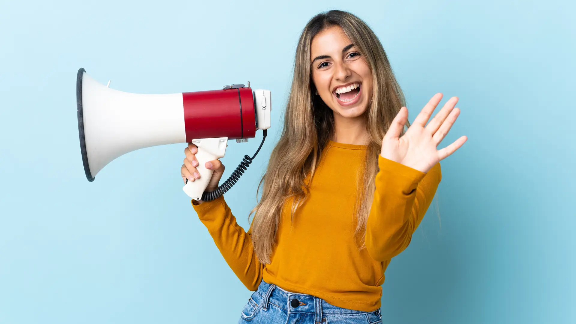 Una chica con un megáfono sobre un fondo azul que representa las opiniones de Previsora General Una chica con un megáfono sobre un fondo azul que representa las opiniones de Previsora General