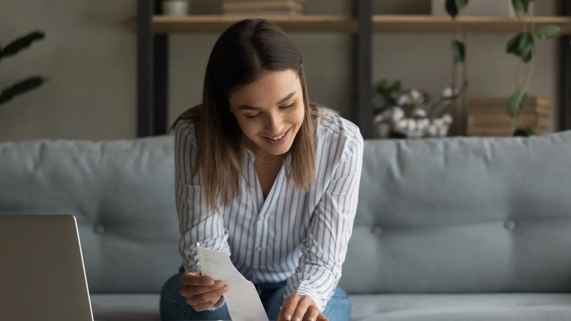 Una mujer mirando unos papeles para vecuanto tiene que pagar de recibo en su seguro de Qualitas Auto Una mujer mirando unos papeles para vecuanto tiene que pagar de recibo en su seguro de Qualitas Auto