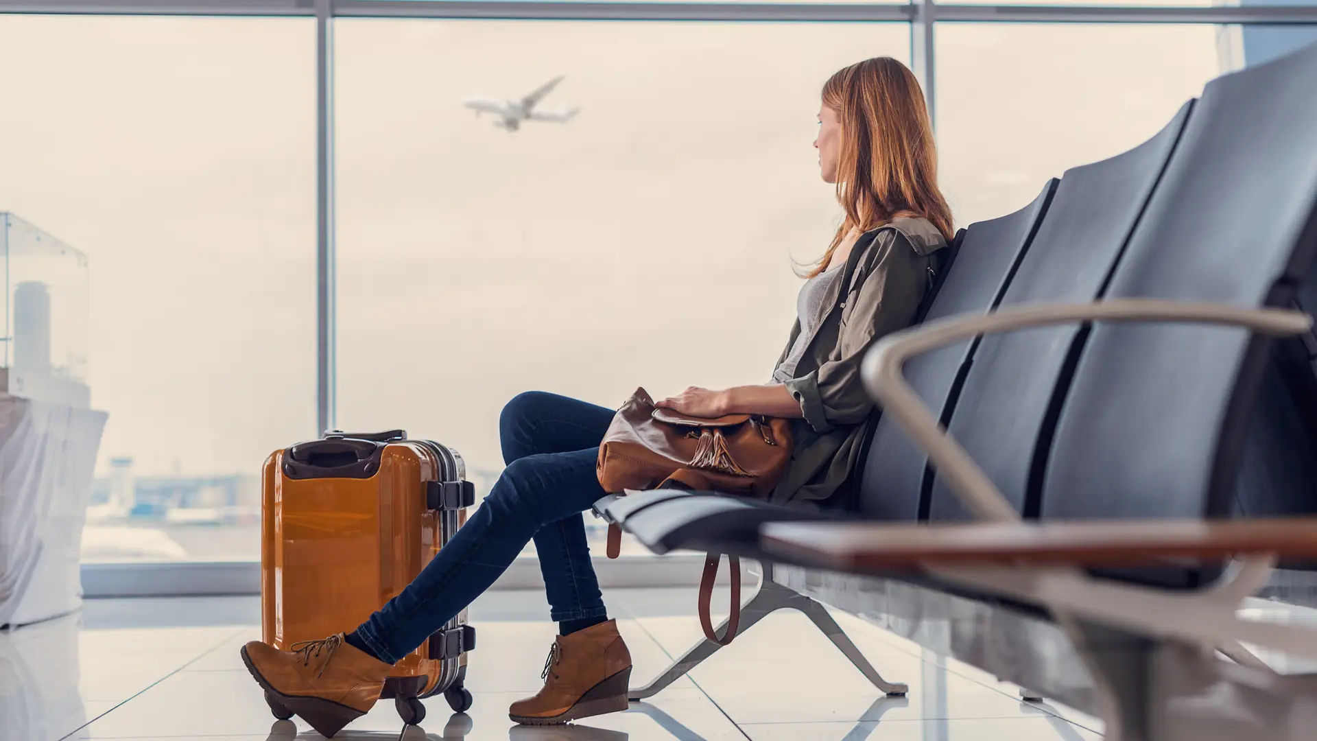 Mujer esperando a su avión para irse de vacaciones con seguro de viaje contratado con el racc Mujer esperando a su avión para irse de vacaciones con seguro de viaje contratado con el racc