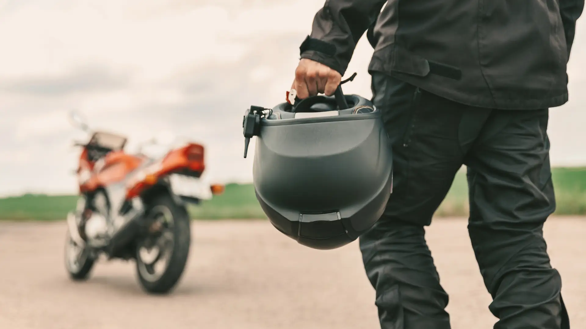joven andando hacia su moto con un seguro epecial de reale con el casco en la mano joven andando hacia su moto con un seguro epecial de reale con el casco en la mano