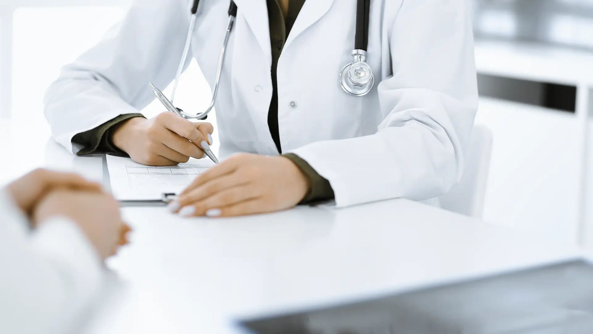 consulta de un medico firmando unos papeles de un paciente que tiene el seguro de salud con reale consulta de un medico firmando unos papeles de un paciente que tiene el seguro de salud con reale