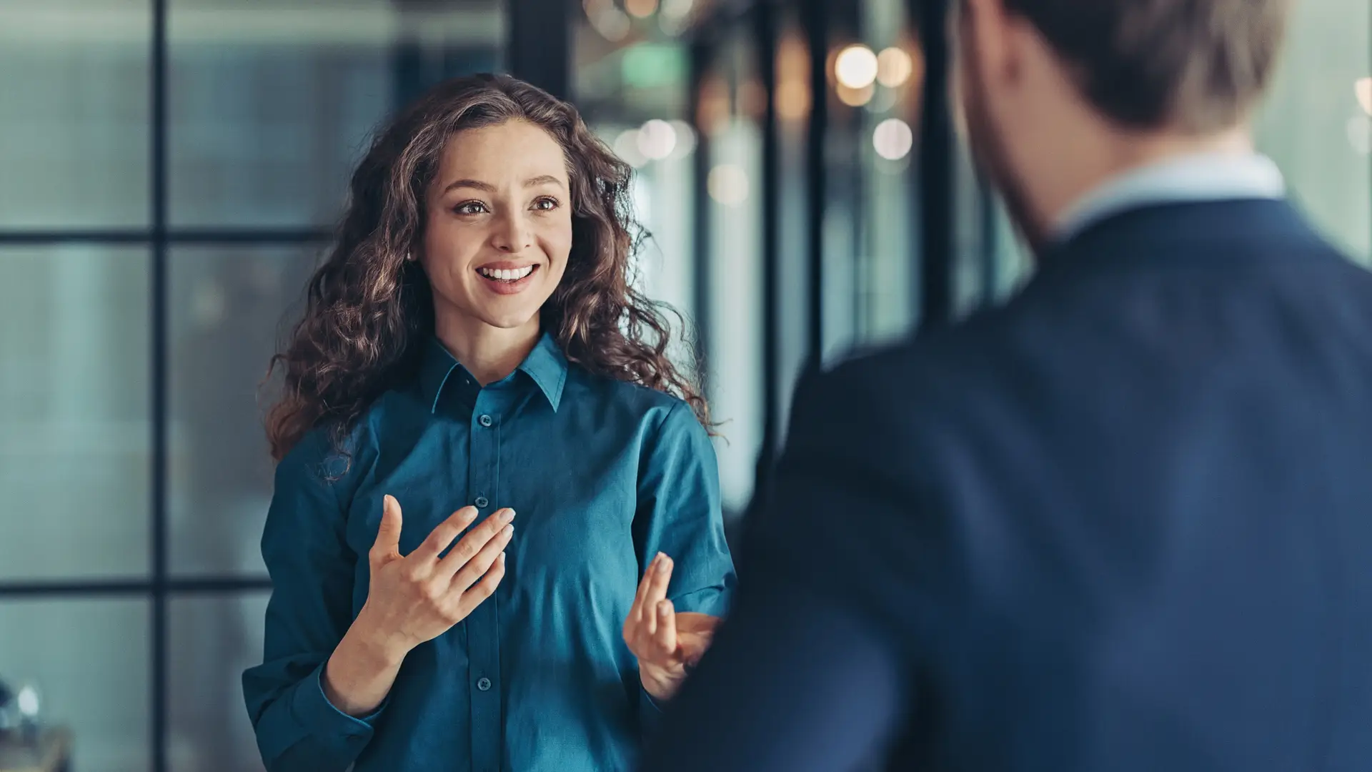 Dos compañeros de trabajo compartiendo opiniones sobre los seguros Regal