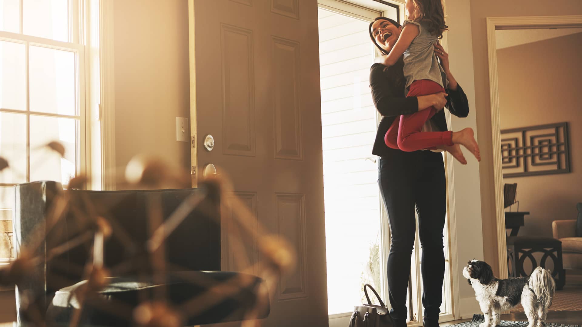 Hija recibiendo a su madre a la puerta de su casa con seguro de hogar en regal Hija recibiendo a su madre a la puerta de su casa con seguro de hogar en regal