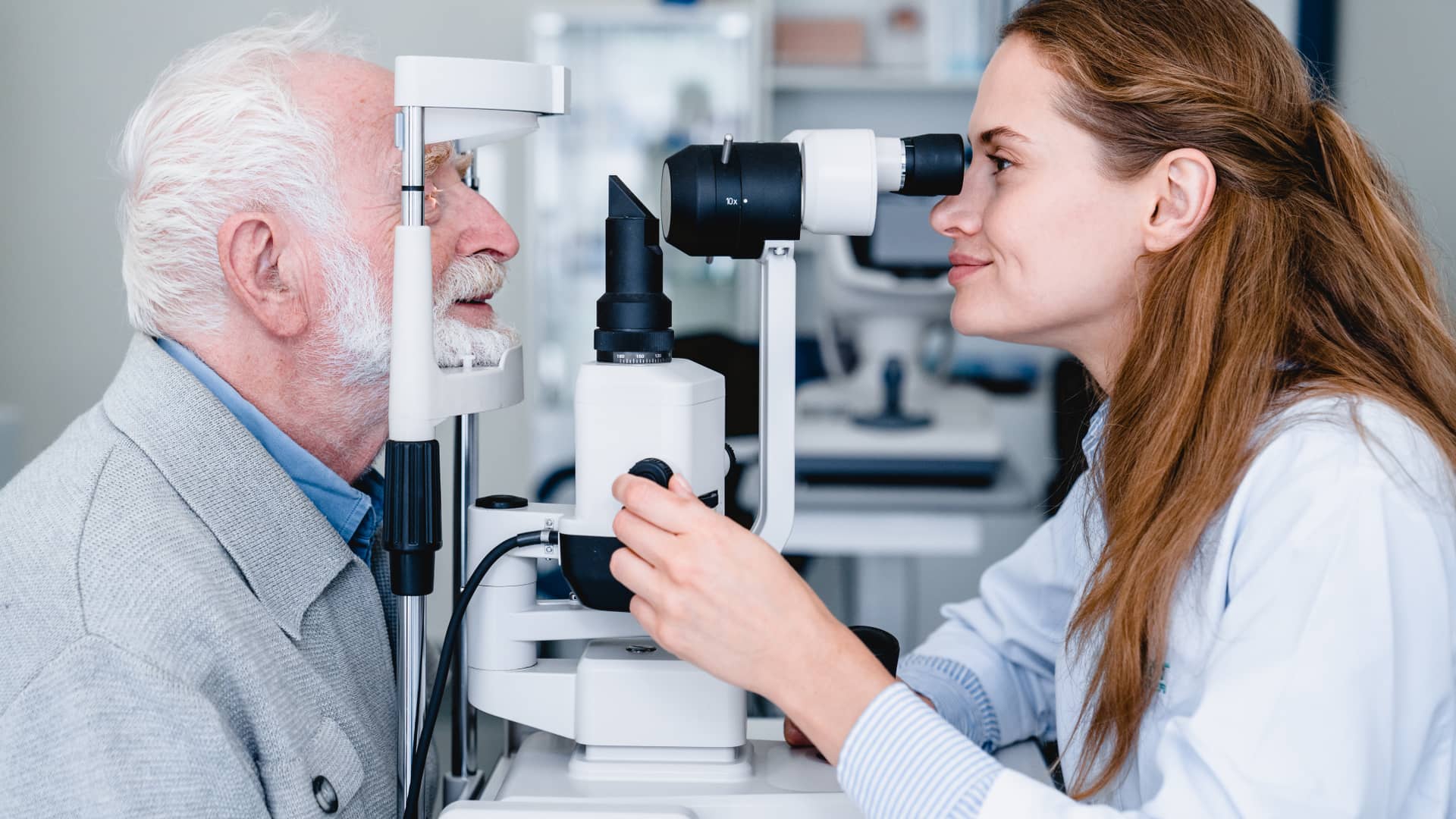 Una oftalmólogo del cuadro médico de Sanitas evluando la vista a un hombre anciano