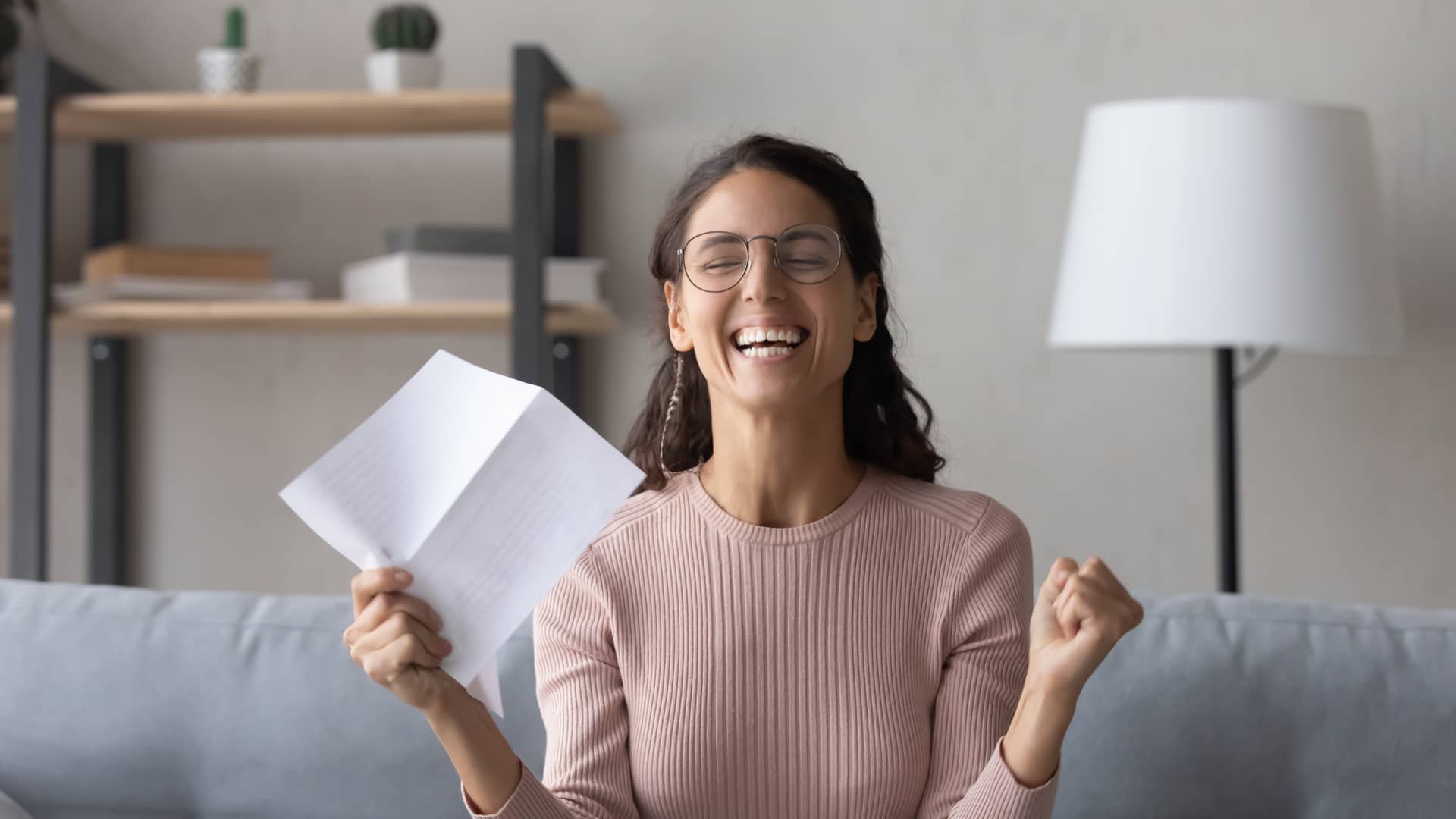 Chica súper contenta al ver en el recibo del seguro todo lo que ha ahorrado con las ofertas de Sanitas