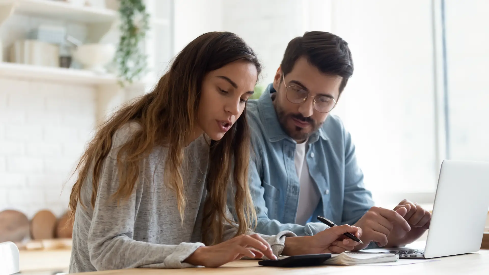 Pareja joven con el ordenador estudiando el precio de los seguros de Sanitas que les interesa contratar Pareja joven con el ordenador estudiando el precio de los seguros de Sanitas que les interesa contratar
