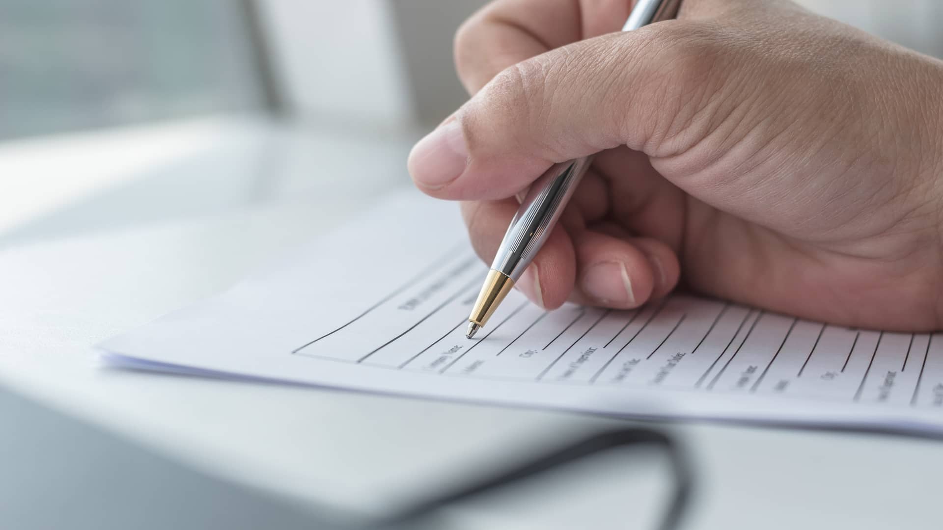 Cliente de Sanitas rellenando los papeles para solicitar una reclamación Cliente de Sanitas rellenando los papeles para solicitar una reclamación