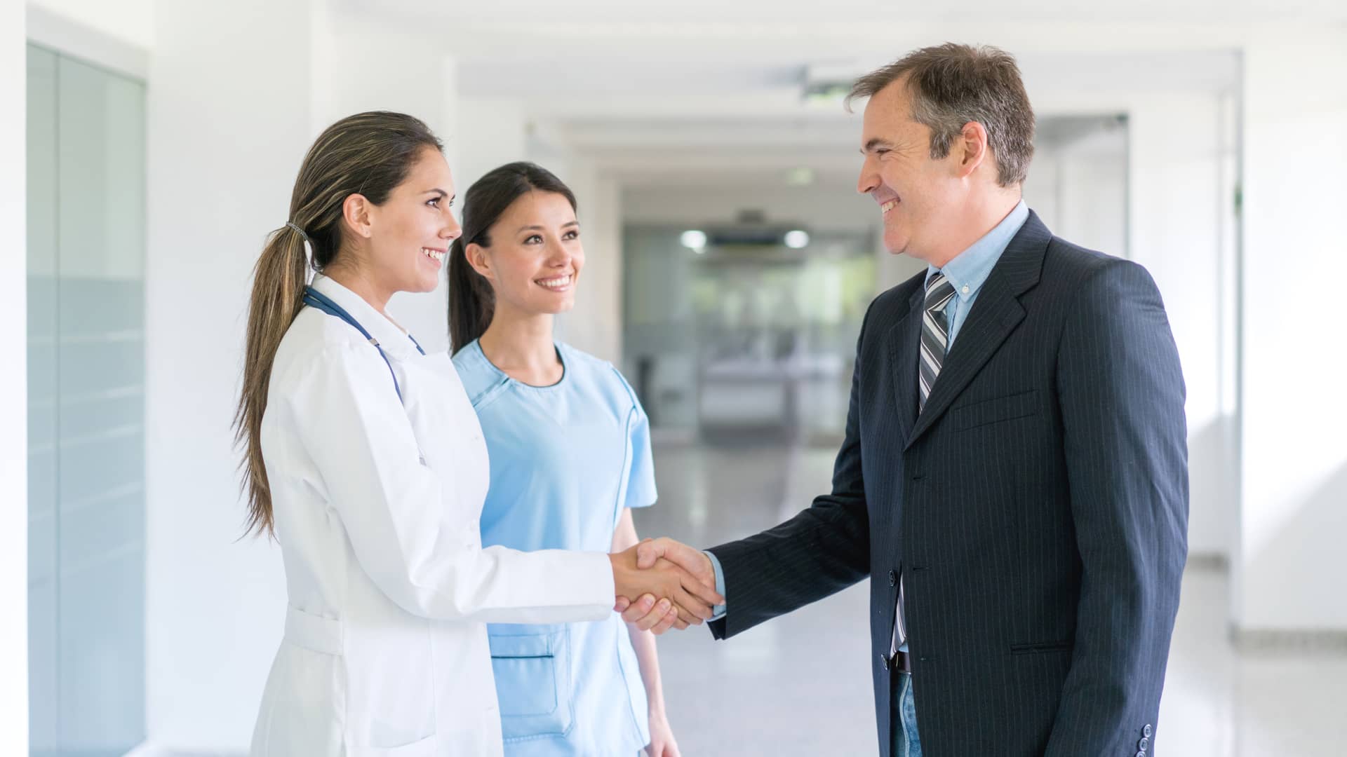 Médico saludando al agente de seguros de salud de santalucia con un apretón de manos Médico saludando al agente de seguros de salud de santalucia con un apretón de manos