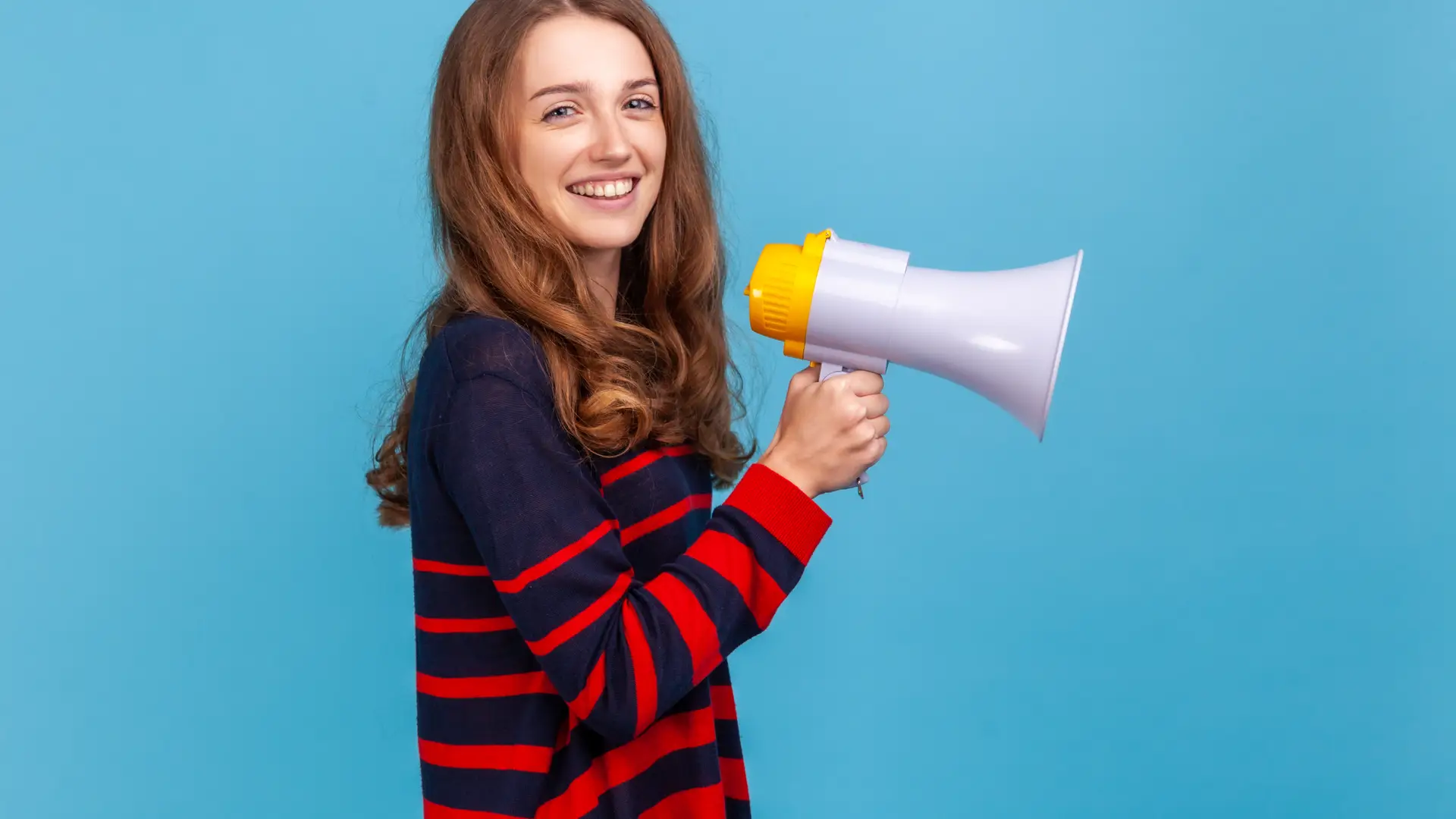 Una chica joven sujetando un megáfono que representa las opiniones de Travelfine