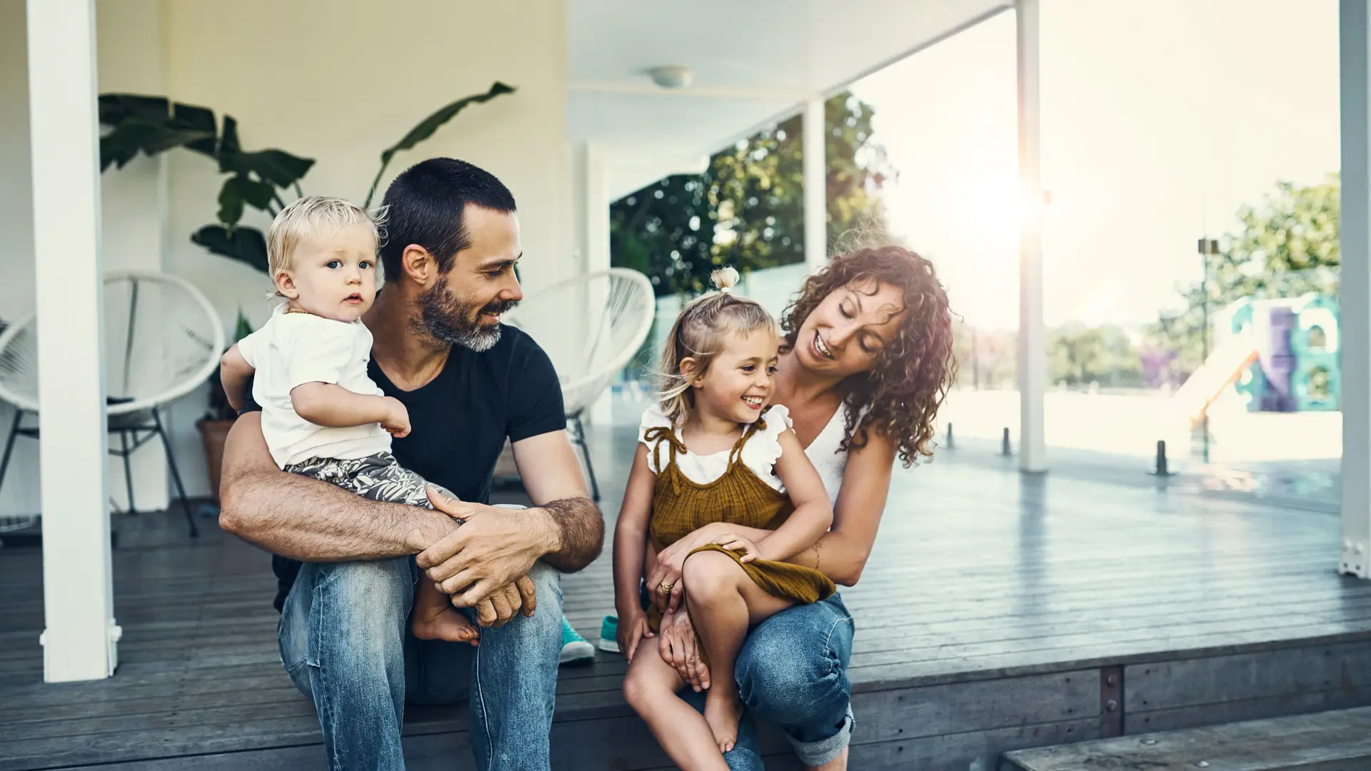Agradable familia sentada en el porche de su casa con seguro de hogar con zurich Agradable familia sentada en el porche de su casa con seguro de hogar con zurich