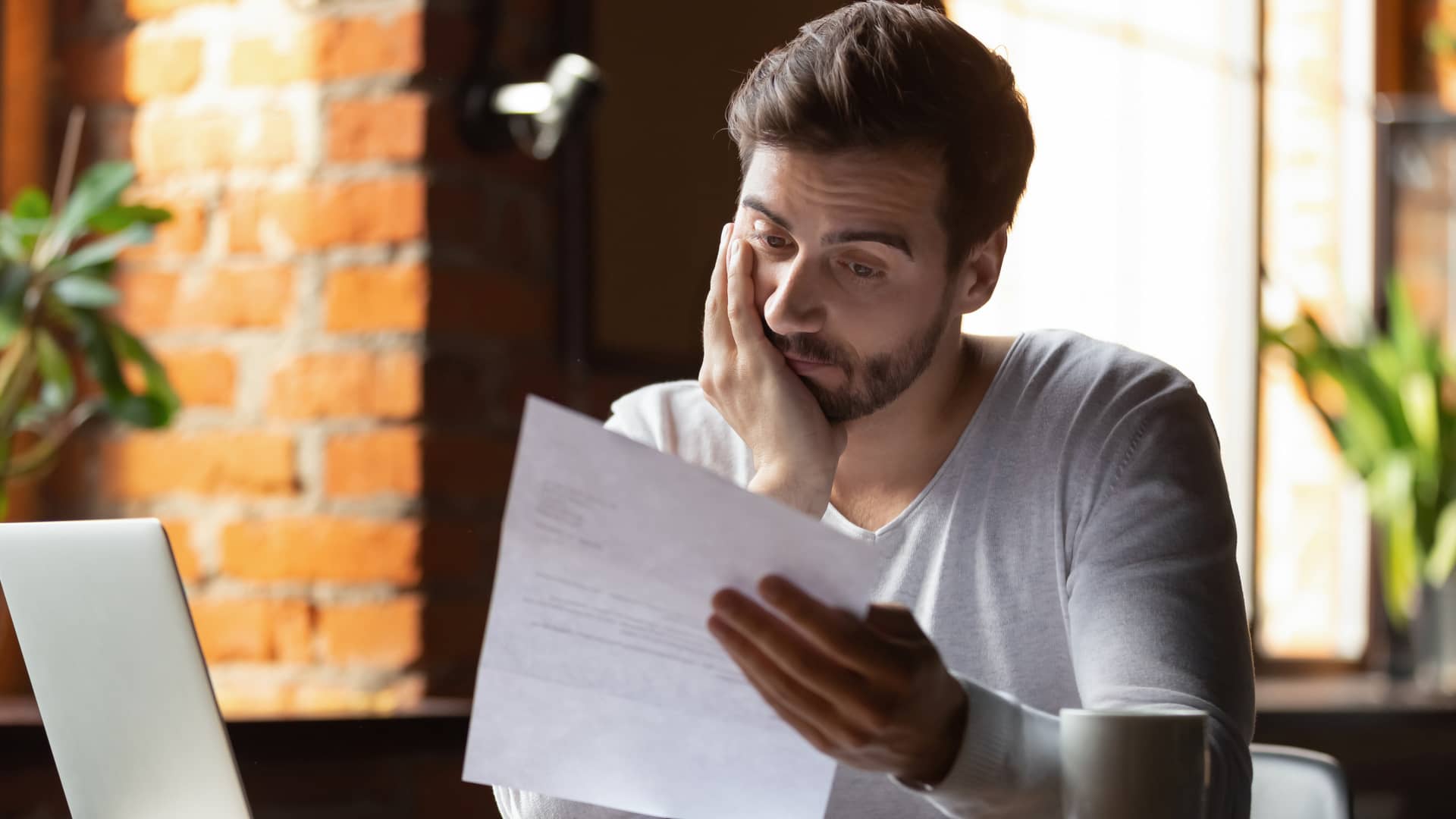 chico joven leyendo en unos papeles los requisitos para contratar un seguro de arrendamiento