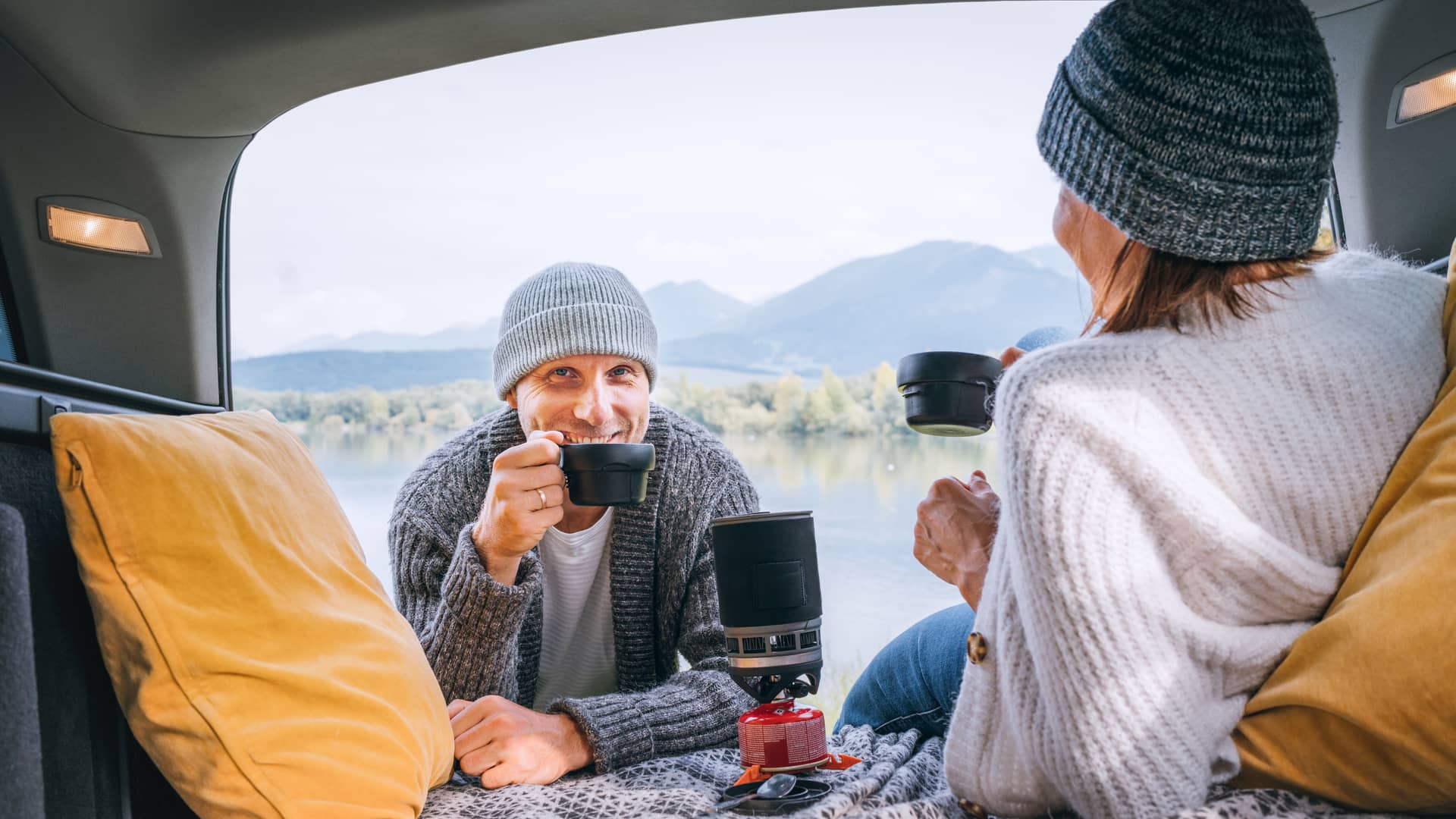 Pareja sonriente tomando un café simboliza la opinión y grado de satisfacción con el seguro de autocaravana Pareja sonriente tomando un café simboliza la opinión y grado de satisfacción con el seguro de autocaravana
