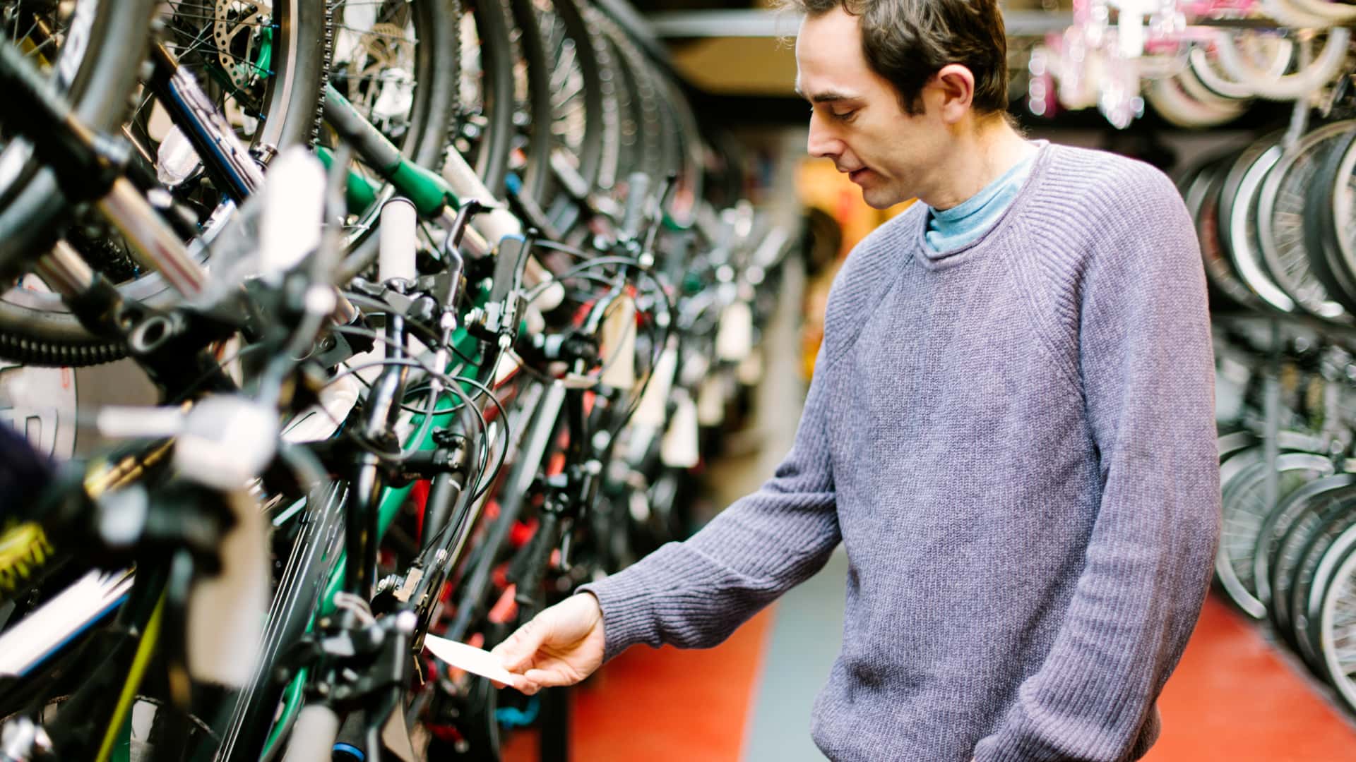 Hombre revisando el precio de la bicilceta que quiere comprar Hombre revisando el precio de la bicilceta que quiere comprar