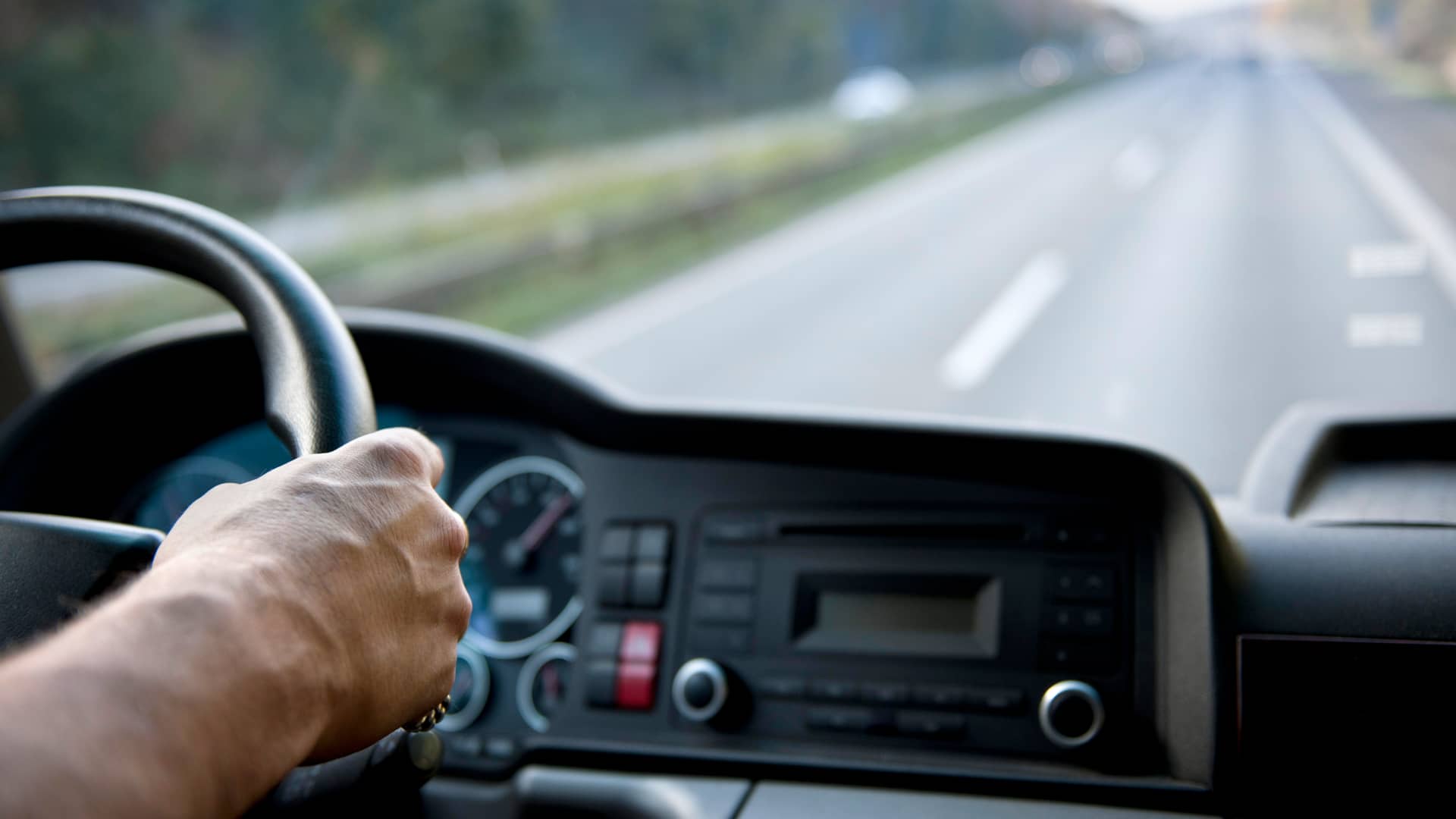 Hombre conduciendo cabeza tractora de camión por autovía Hombre conduciendo cabeza tractora de camión por autovía