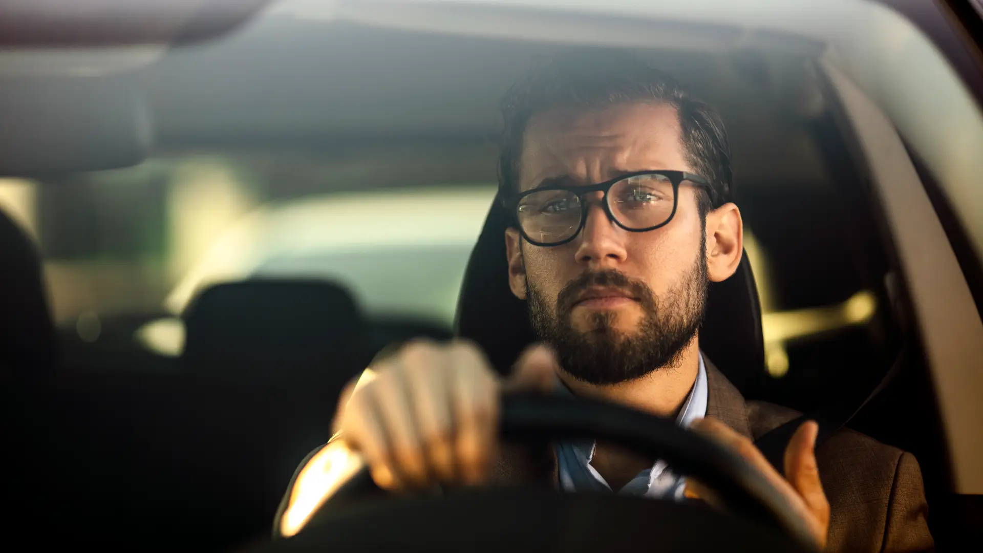 Hombre de negocios conduciendo su coche con numerosos extras asegurados Hombre de negocios conduciendo su coche con numerosos extras asegurados