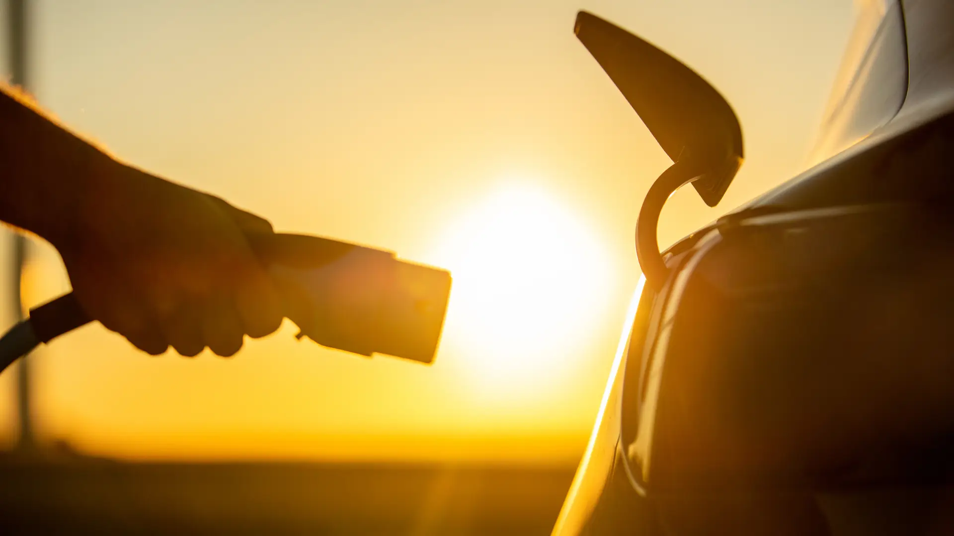 Persona usando cargador eléctrico de enchufe manual en su vehículo Persona usando cargador eléctrico de enchufe manual en su vehículo