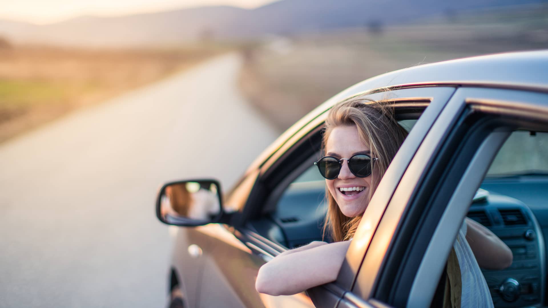 Mujer sonriente y contenta con su nuevo coche de leasing con seguro con todo tipo de coberturas Mujer sonriente y contenta con su nuevo coche de leasing con seguro con todo tipo de coberturas
