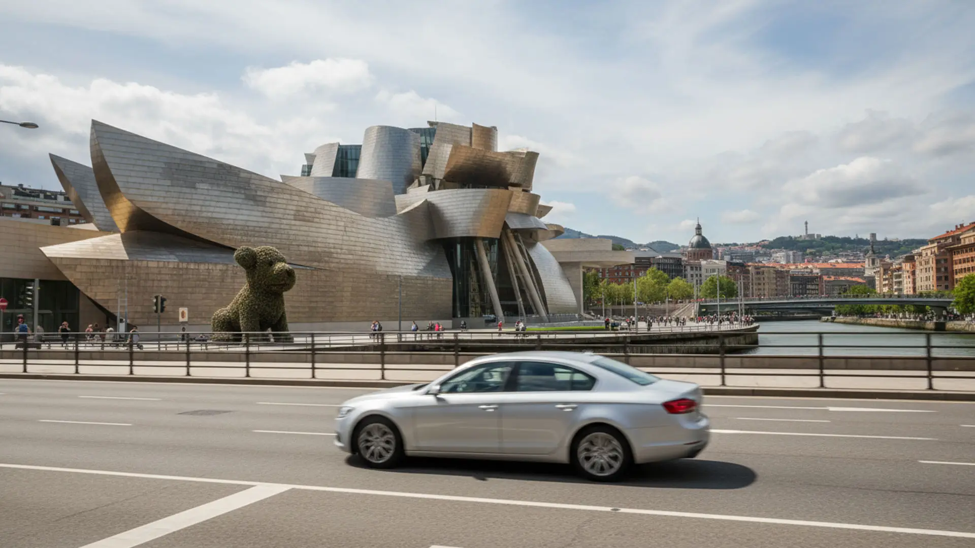 Coche circulando por Bilbao frente al Museo Guggenheim en un día soleado. Coche circulando por Bilbao frente al Museo Guggenheim en un día soleado.