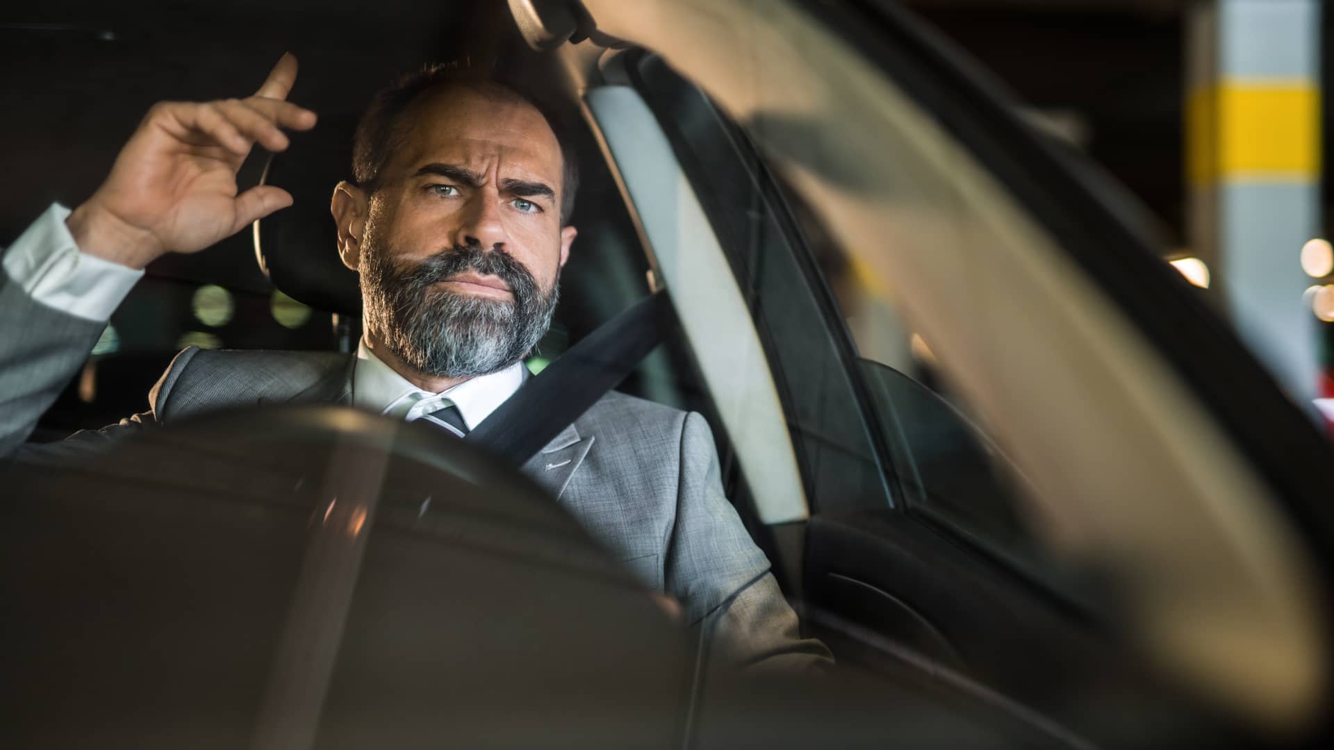 Hombre conduciendo su coche enfadado porque le han subida la prima del seguro del coche