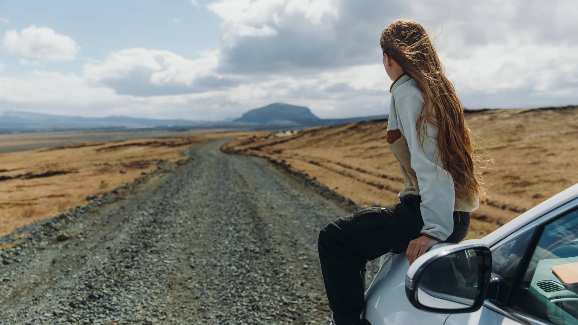 Mujer con su coche de viaje por Islandia con un seguro para coche en el extranjero contratado Mujer con su coche de viaje por Islandia con un seguro para coche en el extranjero contratado