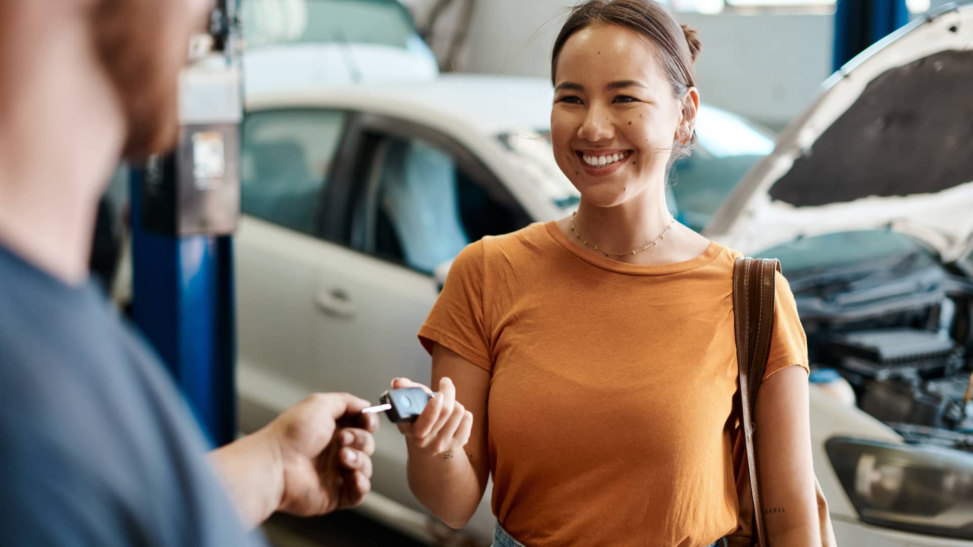 Mujer entregando las llaves de su vehículo para realizar revisión ya que su seguro le ofrece un vehículo de sustitución