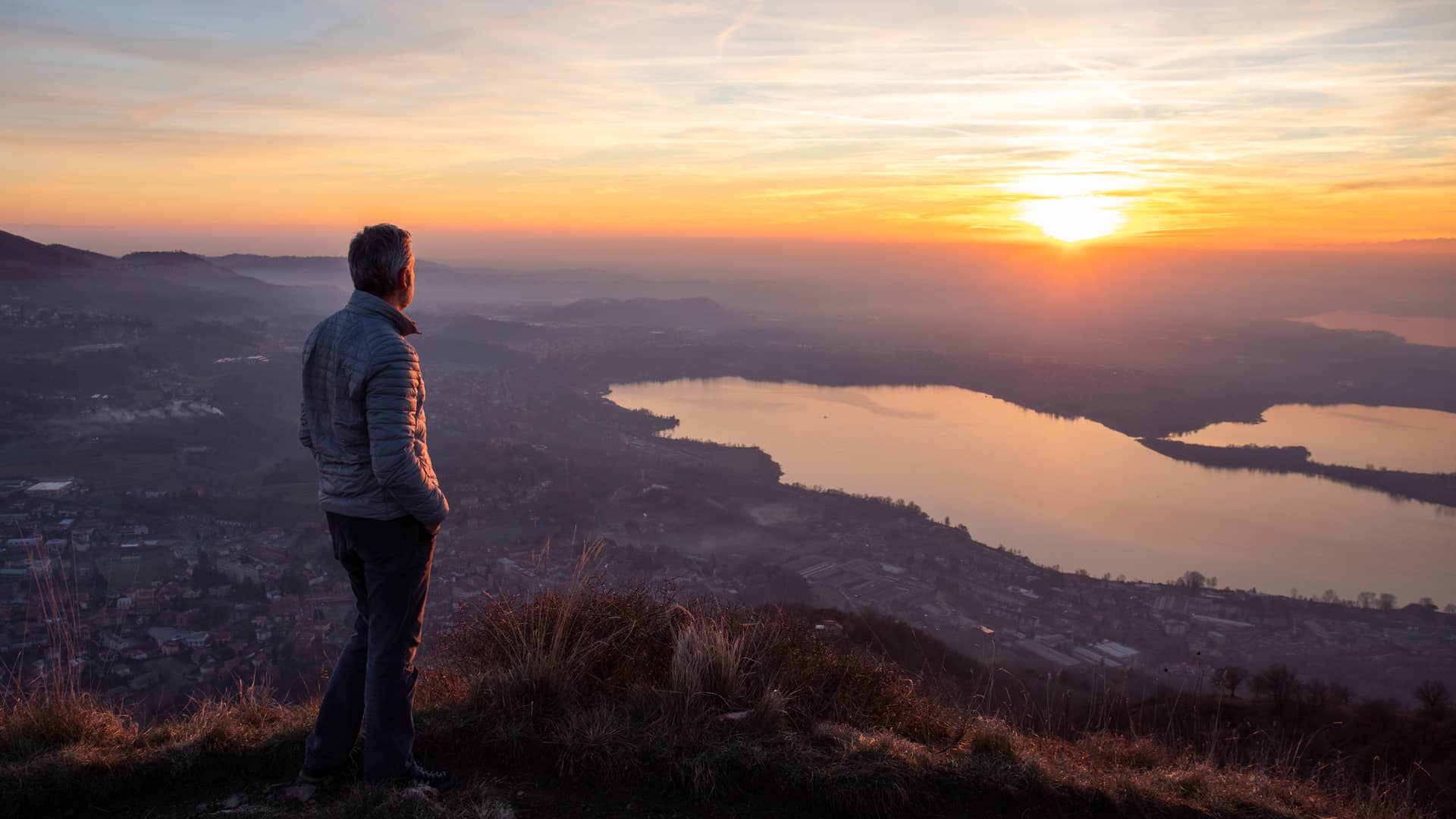 Hombre mirando el atardecer desde lo alto pensando si tendra carencia en su seguro de decesos