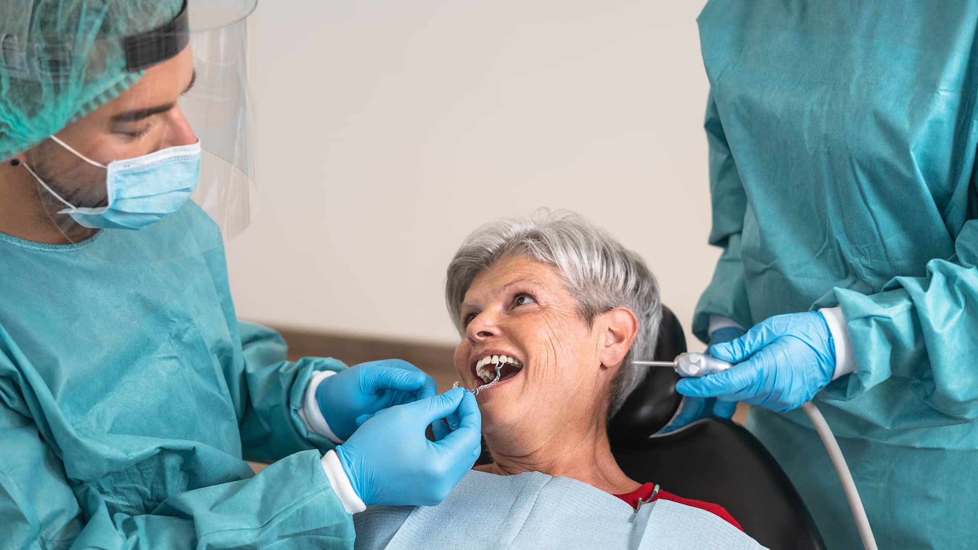 Mujer en clinica dental poniendose implantes con su seguro dental