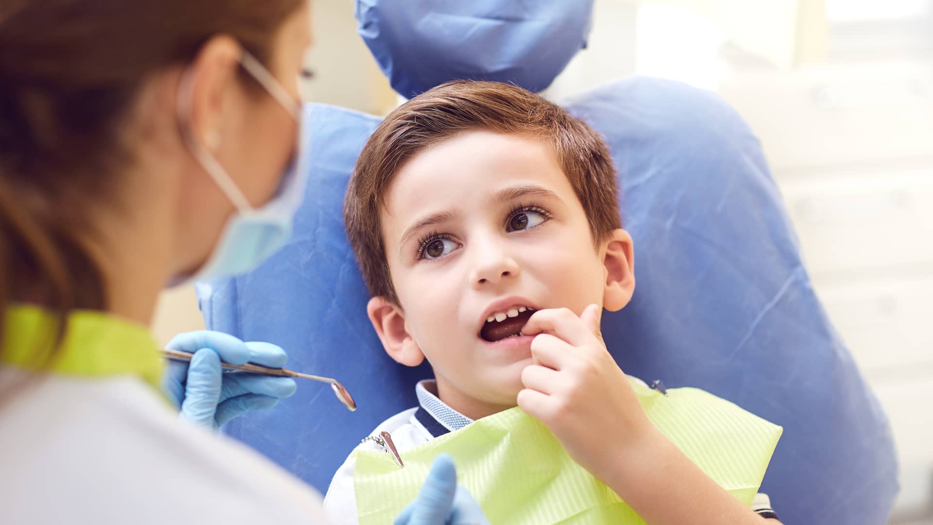 Niño con seguro dental acudiendo a cita con su dentista Niño con seguro dental acudiendo a cita con su dentista